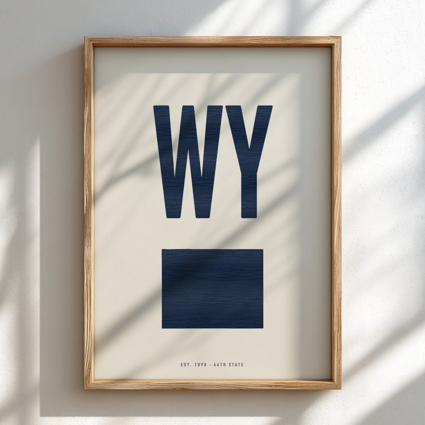 Framed artwork with 'WY' in blue on a beige background