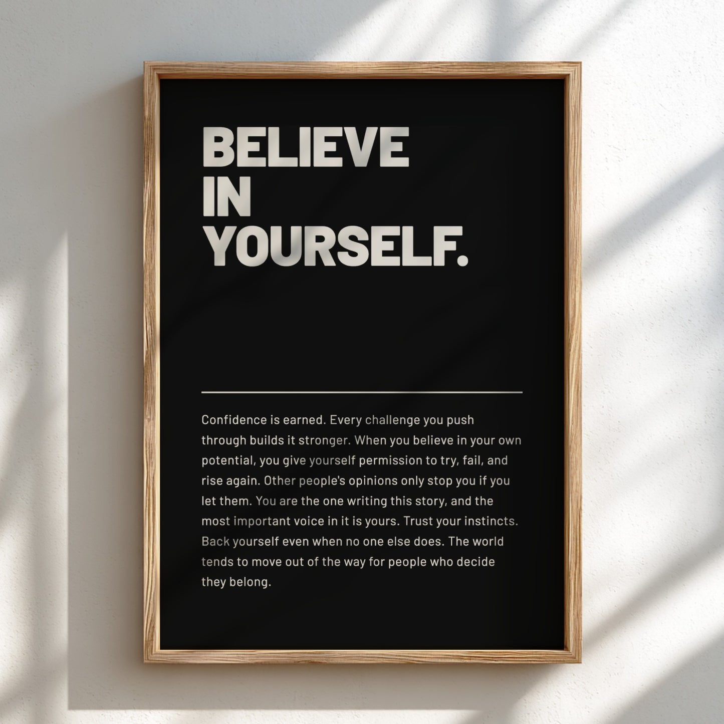 Framed poster with motivational quote 'BELIEVE IN YOURSELF' on a black background