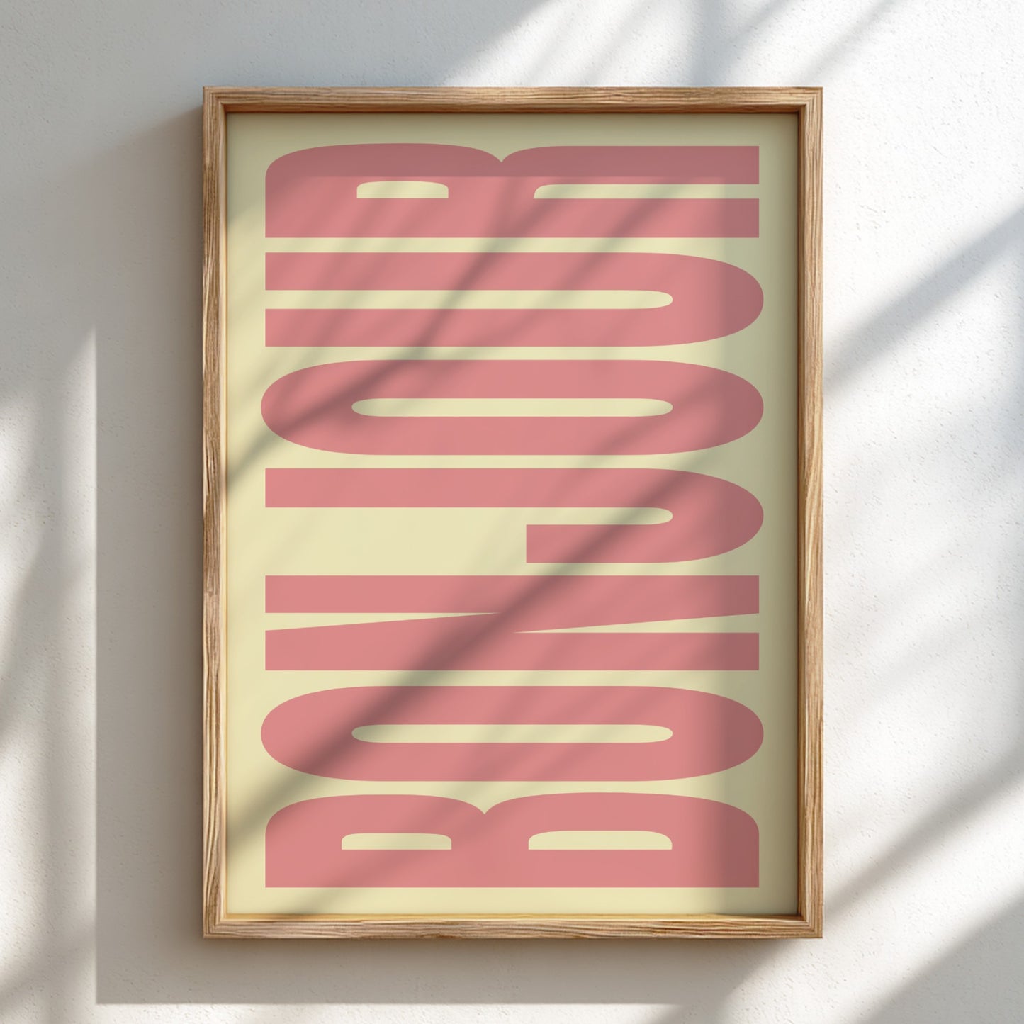 Framed artwork with 'Bonjour' text in pink on a light background