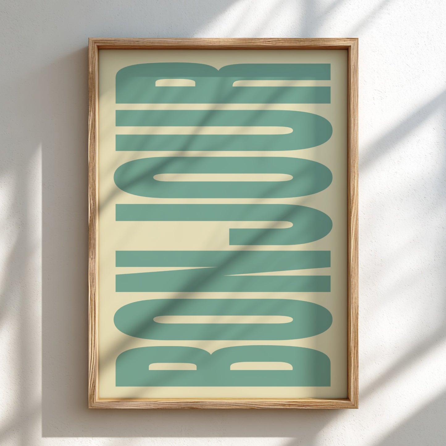 Framed artwork with 'BONJOUR' text in teal on a beige background