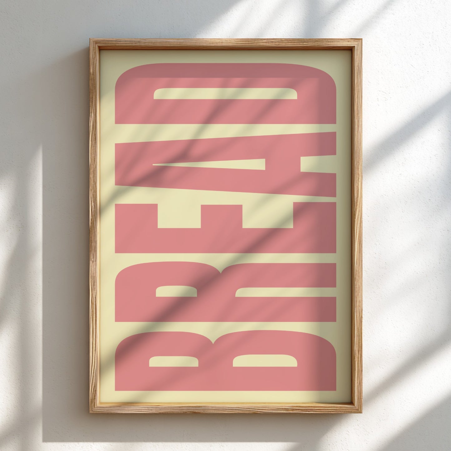 Framed artwork with 'BREAD' in pink on a light background