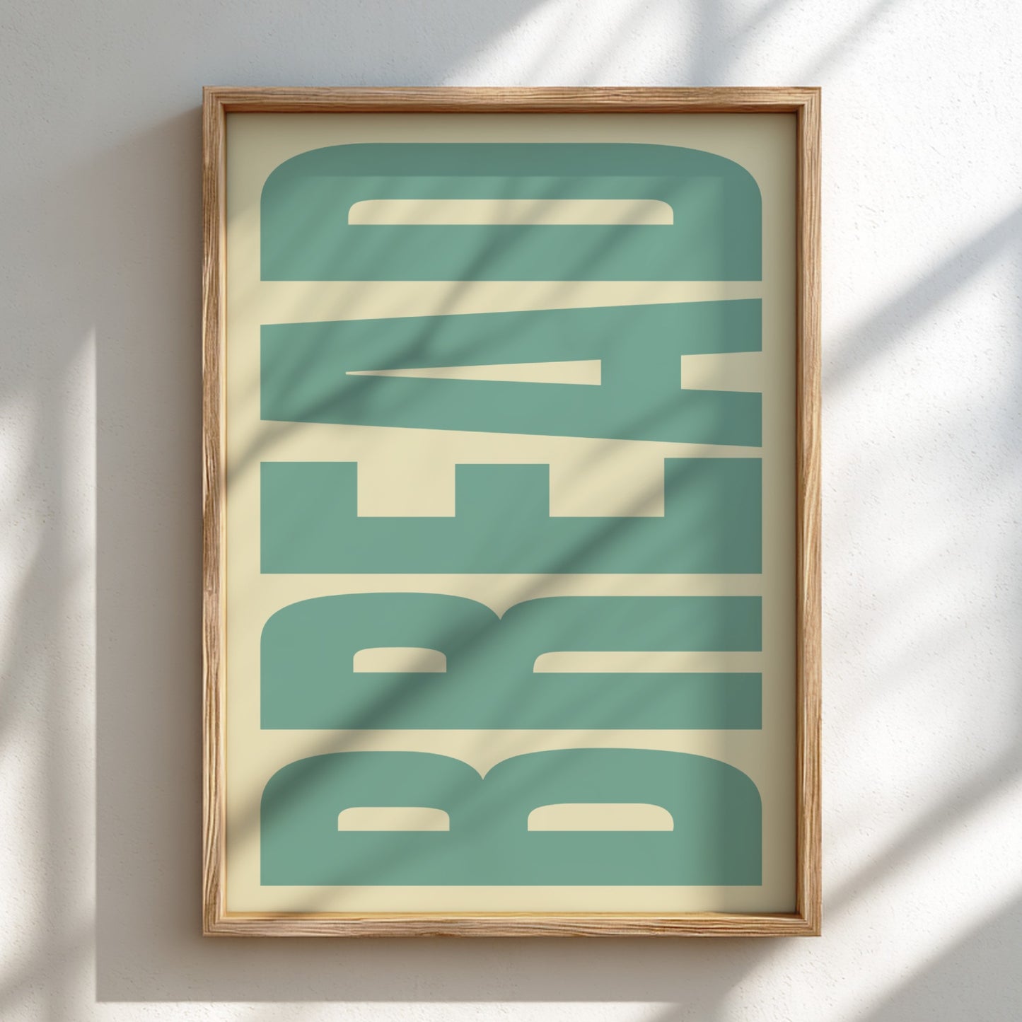 Framed artwork with 'BREAD' text in teal on a beige background