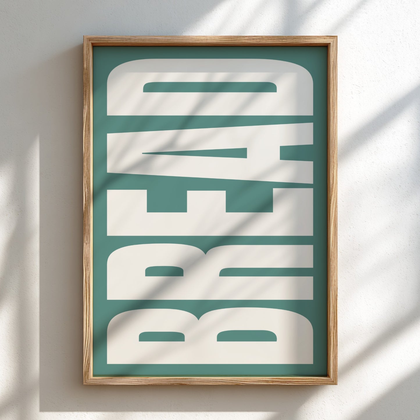 Framed artwork with 'BREAD' text on a teal background