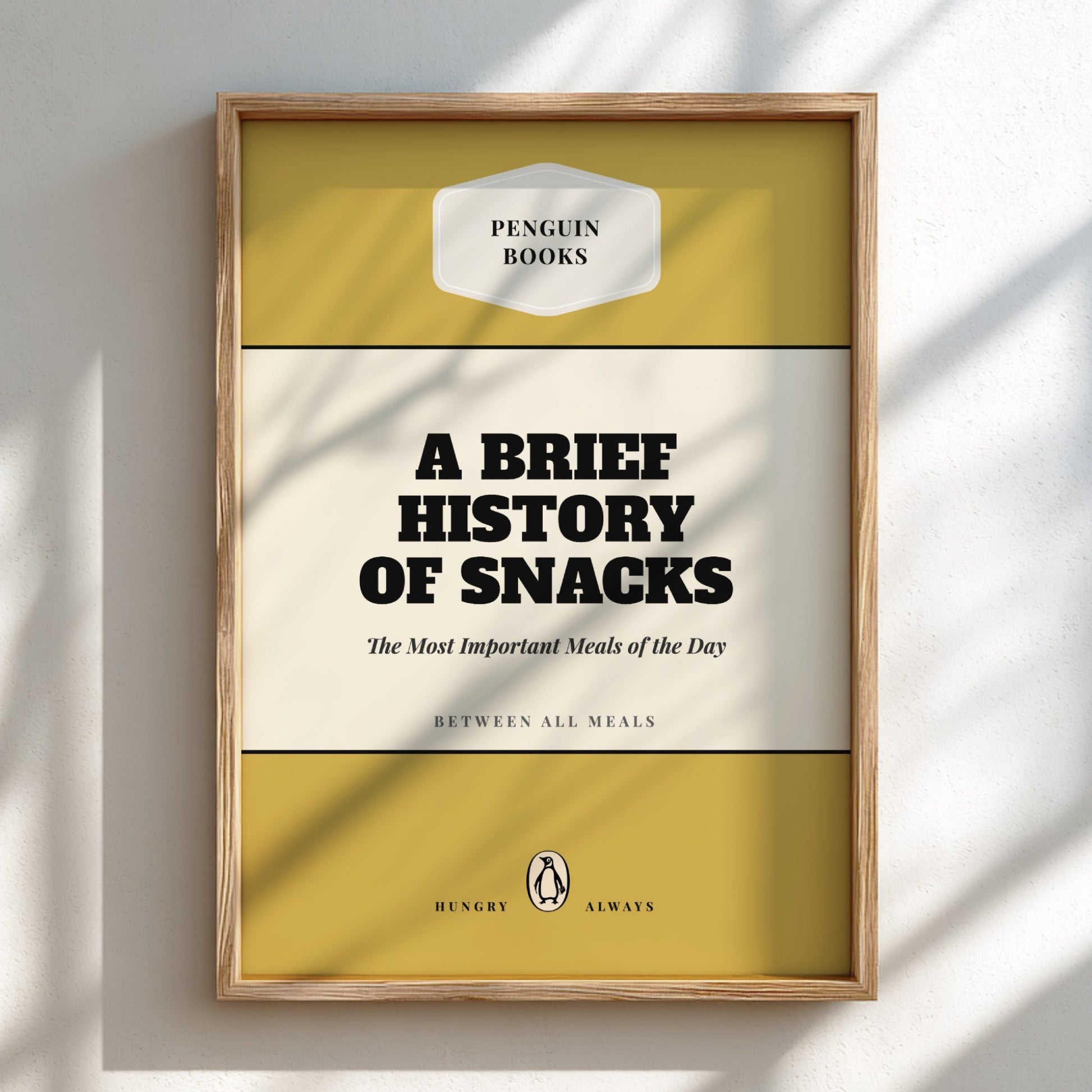 Framed book cover of 'A Brief History of Snacks' by Penguin Books on a light background