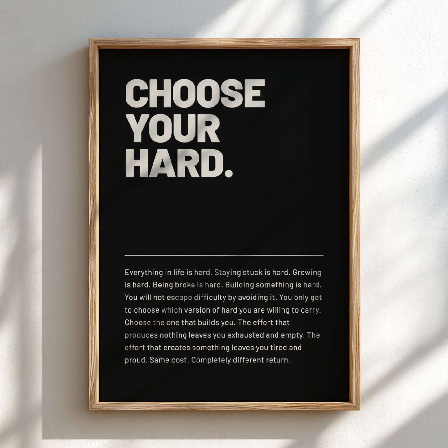 Framed poster with motivational quote 'CHOOSE YOUR HARD.' on a black background.