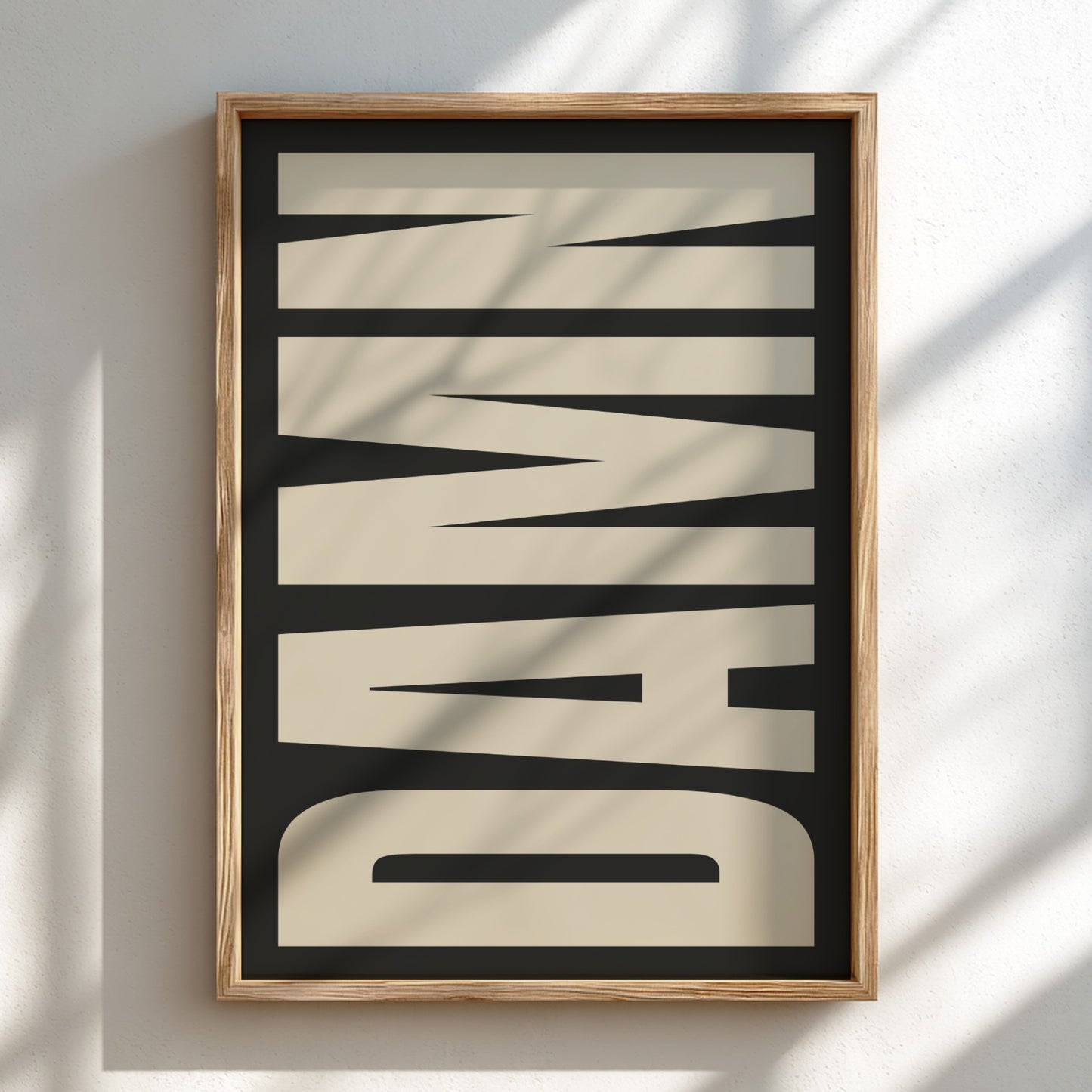Framed artwork with the word 'DAMN' on a light background