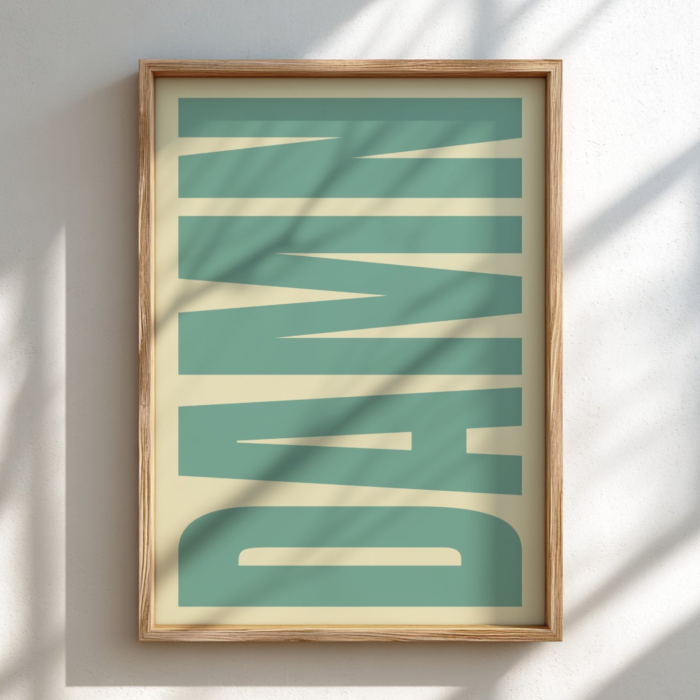 Framed artwork with 'DAMN' in bold letters on a teal background