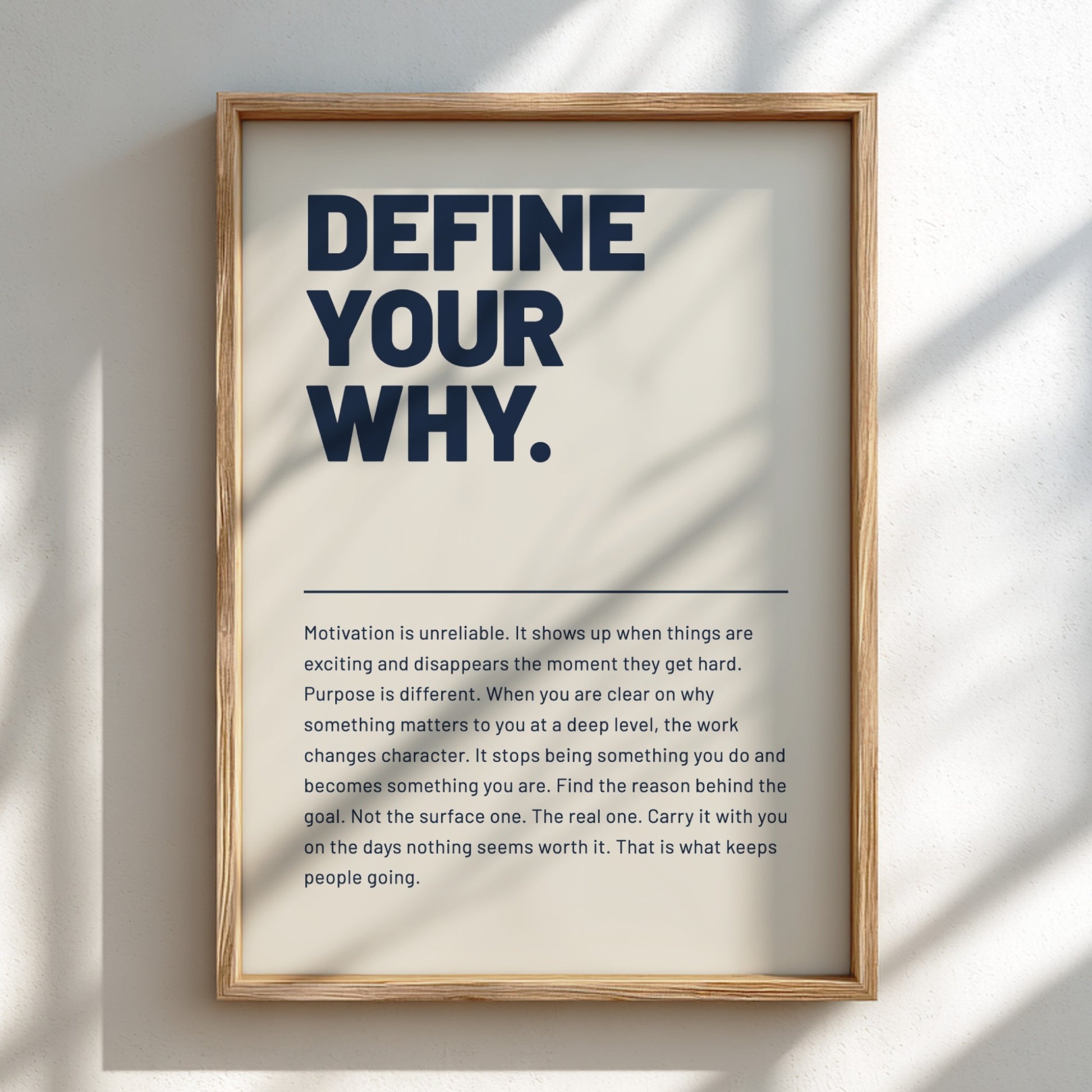 Framed poster with motivational quote 'Define Your Why' on a light background