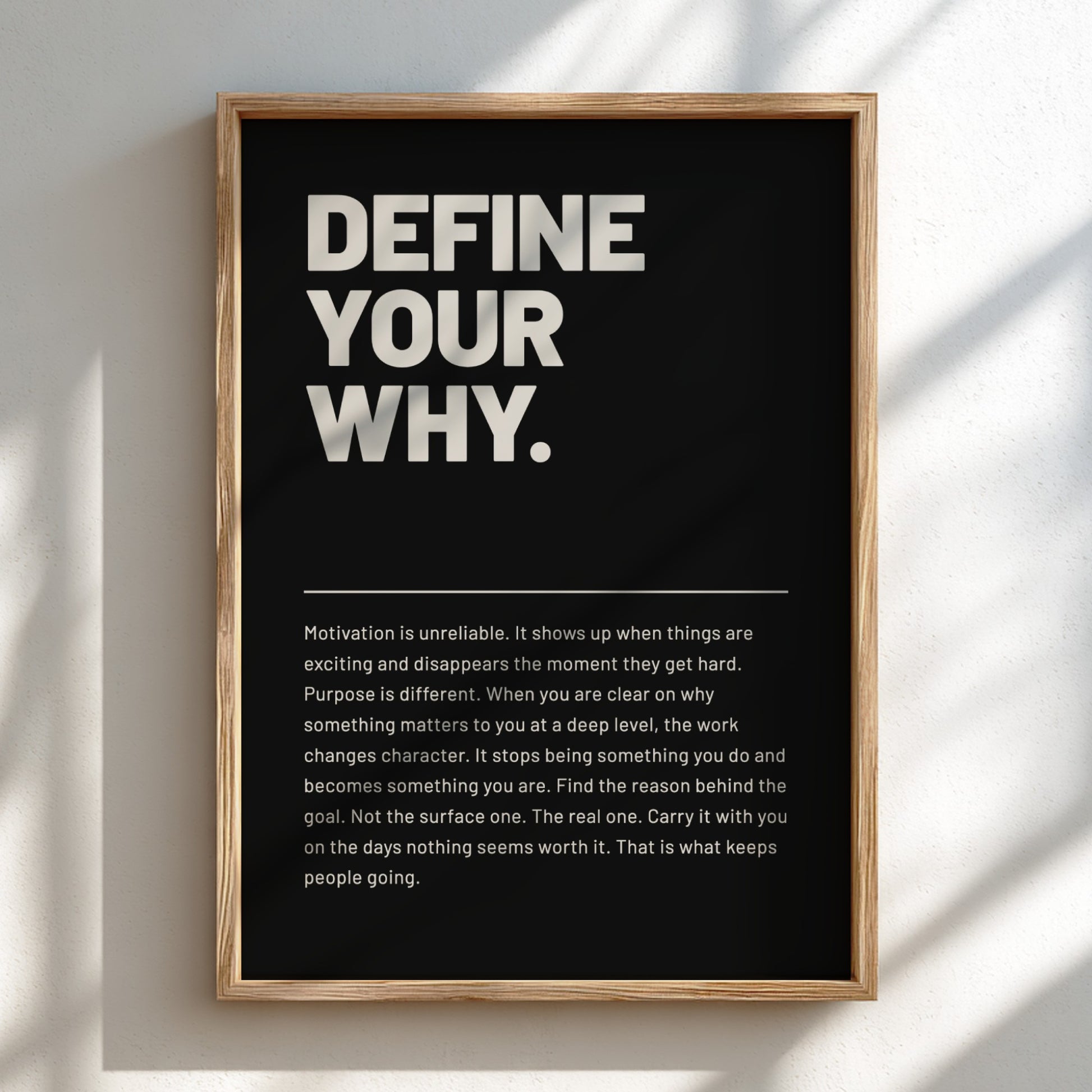 Framed poster with motivational quote 'Define Your Why' on a black background