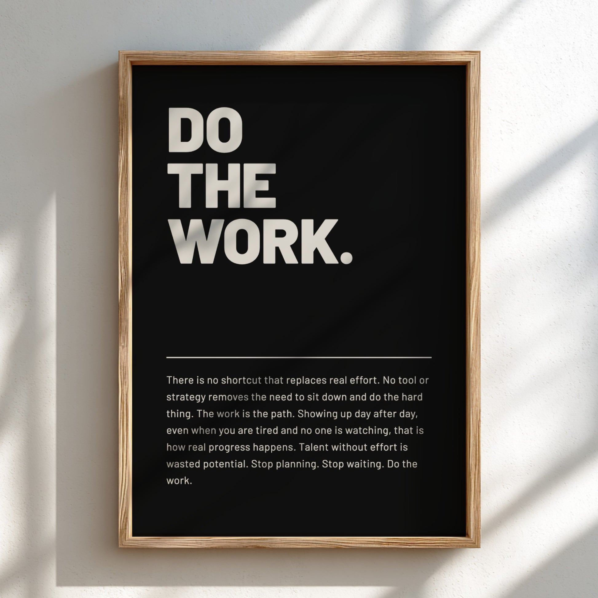 Framed poster with motivational quote 'DO THE WORK.' on a light background