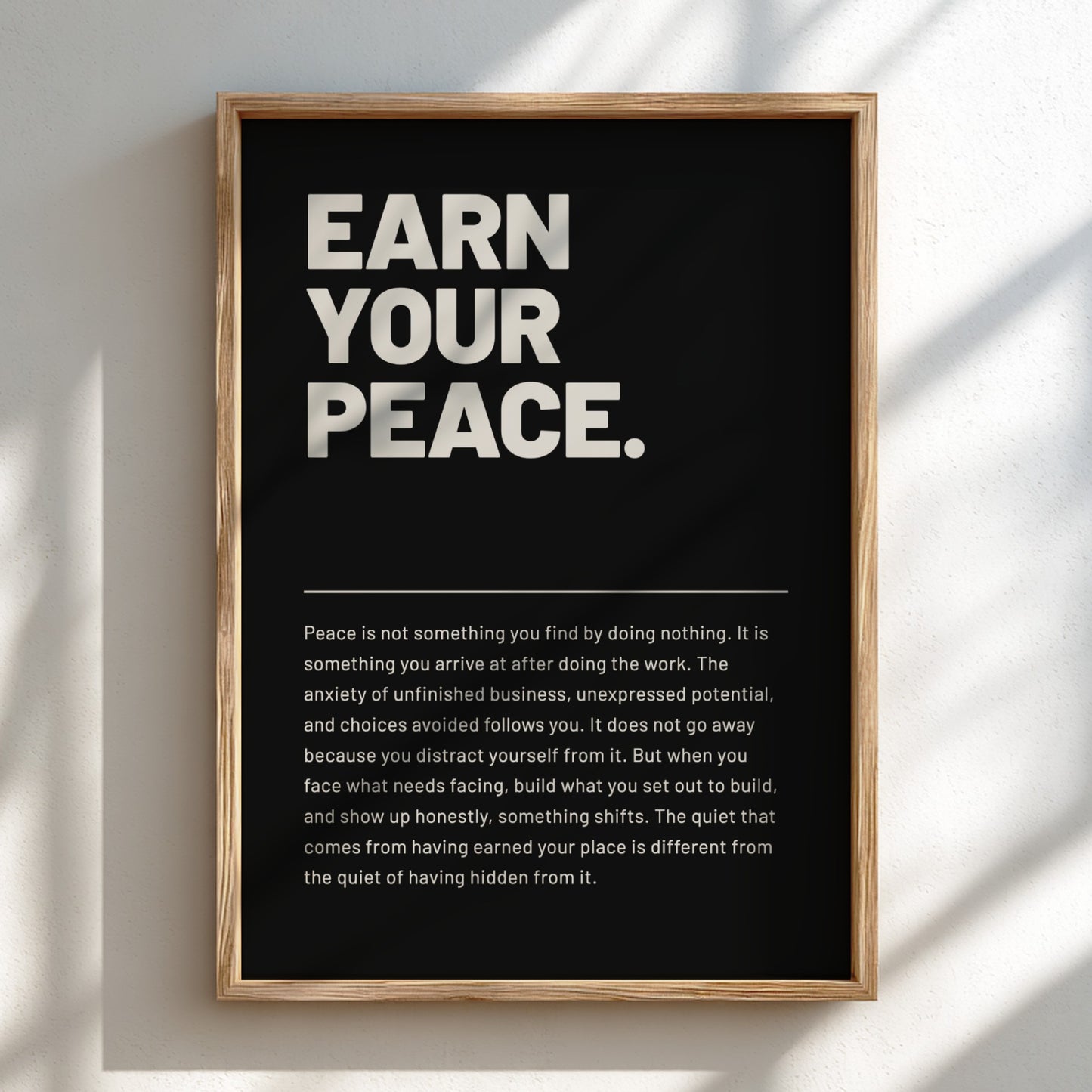 Framed poster with 'Earn Your Peace' text on a black background