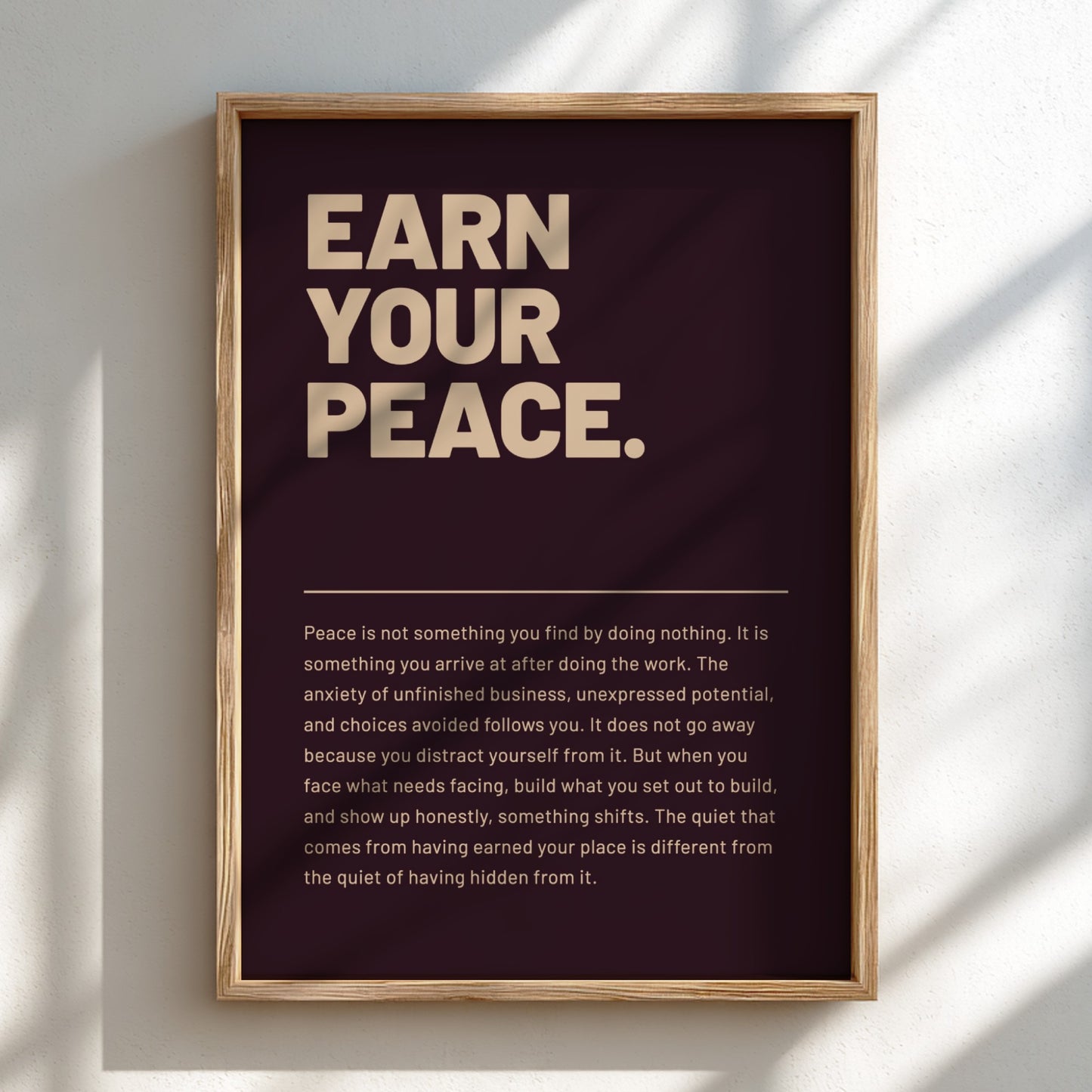 Framed poster with motivational quote 'Earn Your Peace' on a dark background