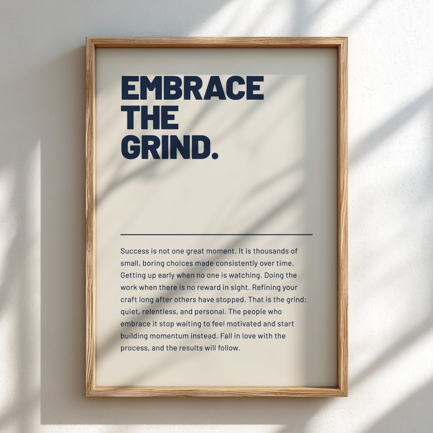 Framed motivational poster with text 'Embrace the Grind' on a light background
