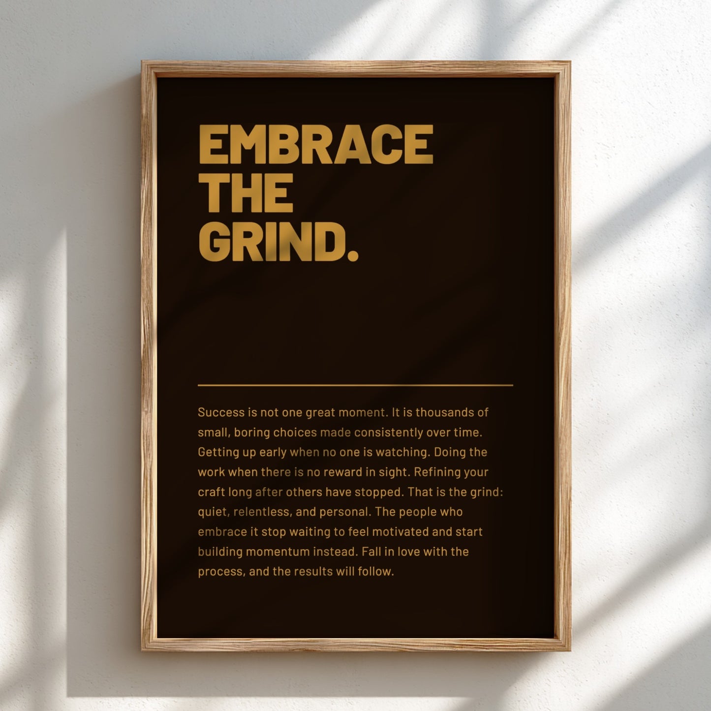 Framed poster with motivational quote 'Embrace the Grind' on a dark background