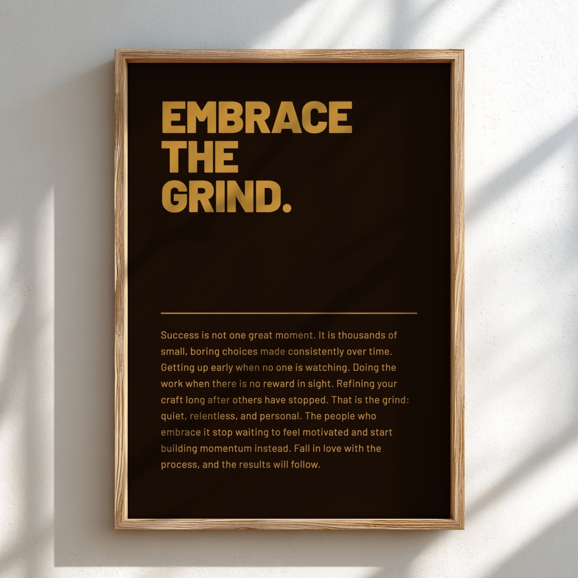 Framed poster with motivational quote 'Embrace the Grind' on a dark background