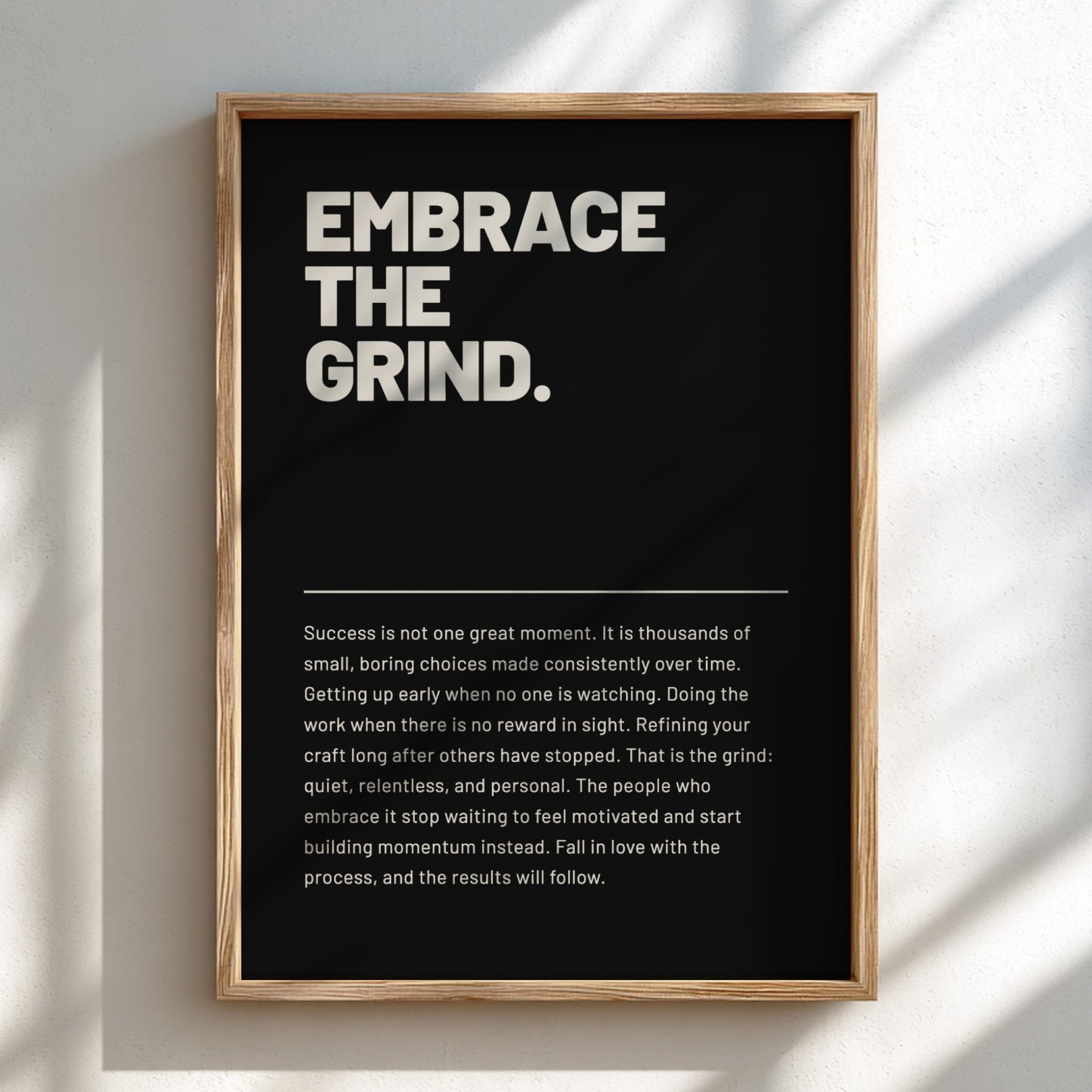 Framed poster with 'Embrace the Grind' text on a black background