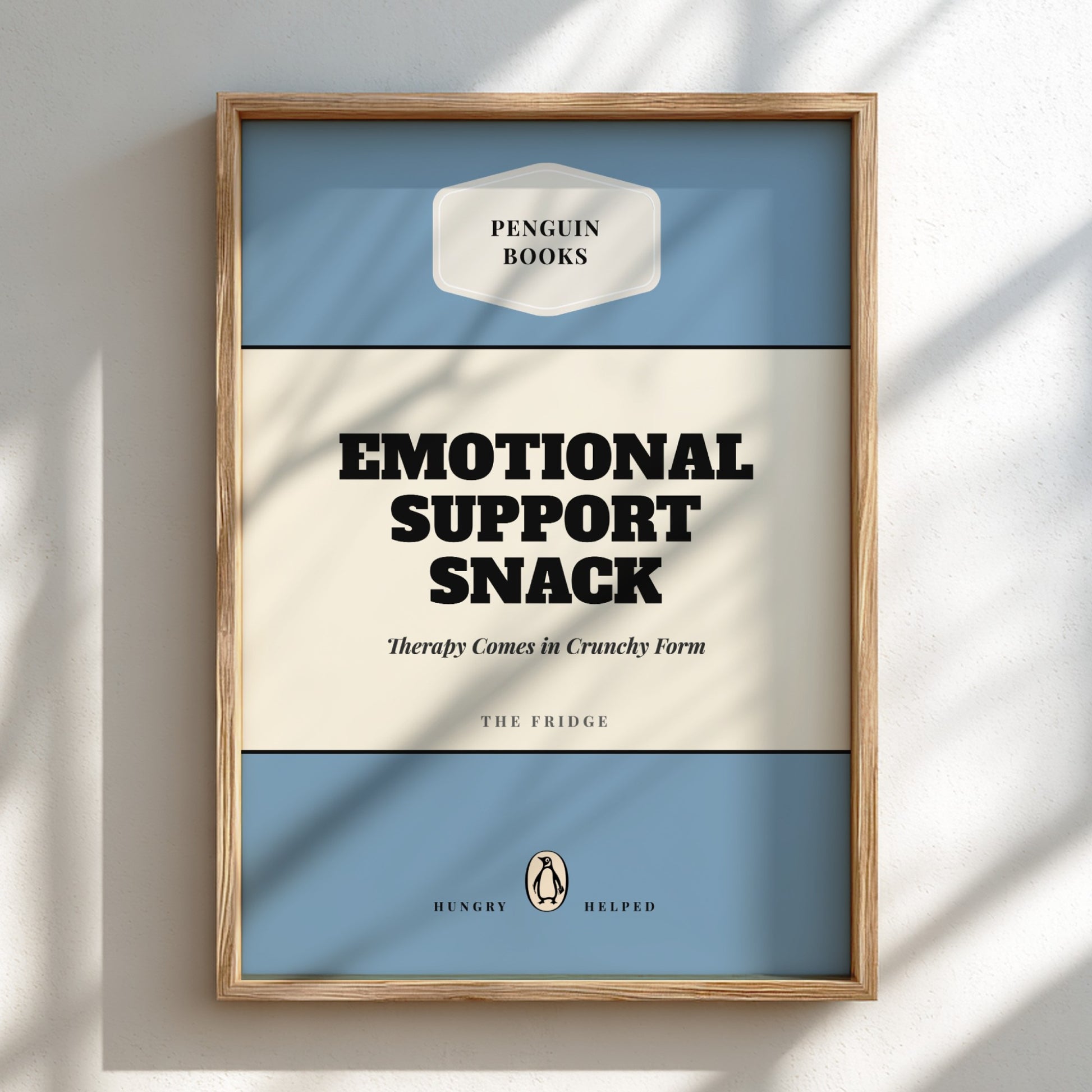 Framed poster with 'Penguin Books' design and text 'Emotional Support Snack' on a light background.