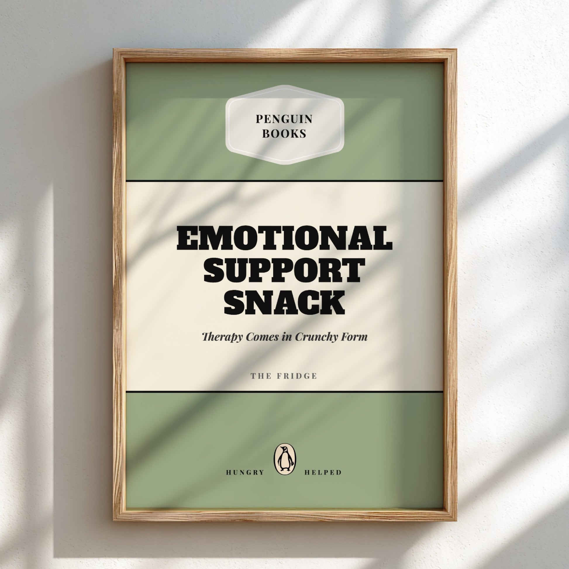 Framed artwork with 'Penguin Books' design and text 'Emotional Support Snack'.
