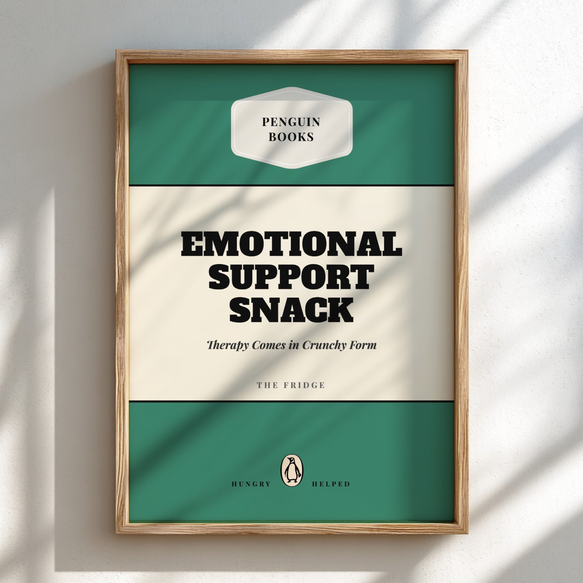 Framed poster with 'Penguin Books' design and text 'Emotional Support Snack' on a light background.