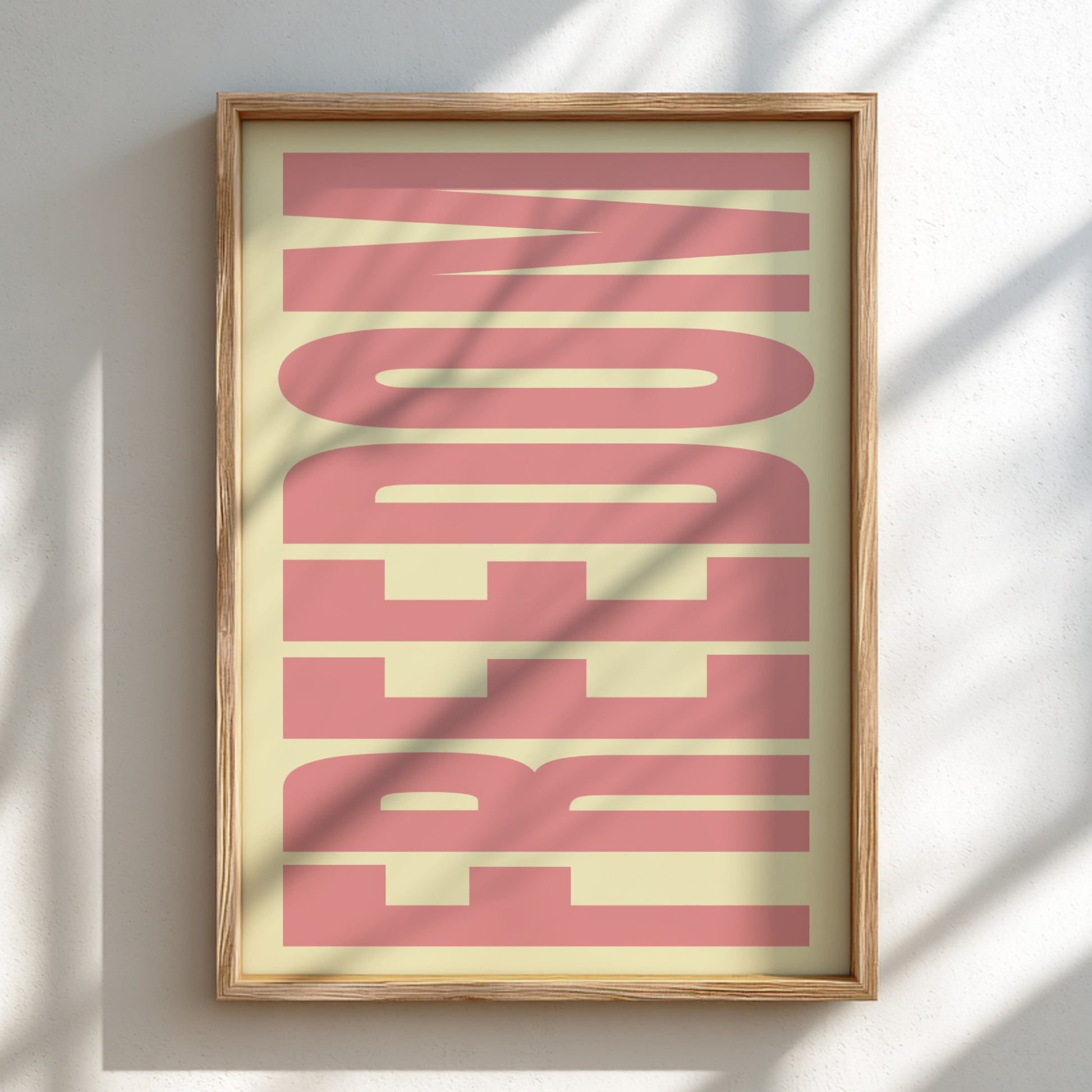 Framed artwork with the word 'FREEDOM' in pink on a light background