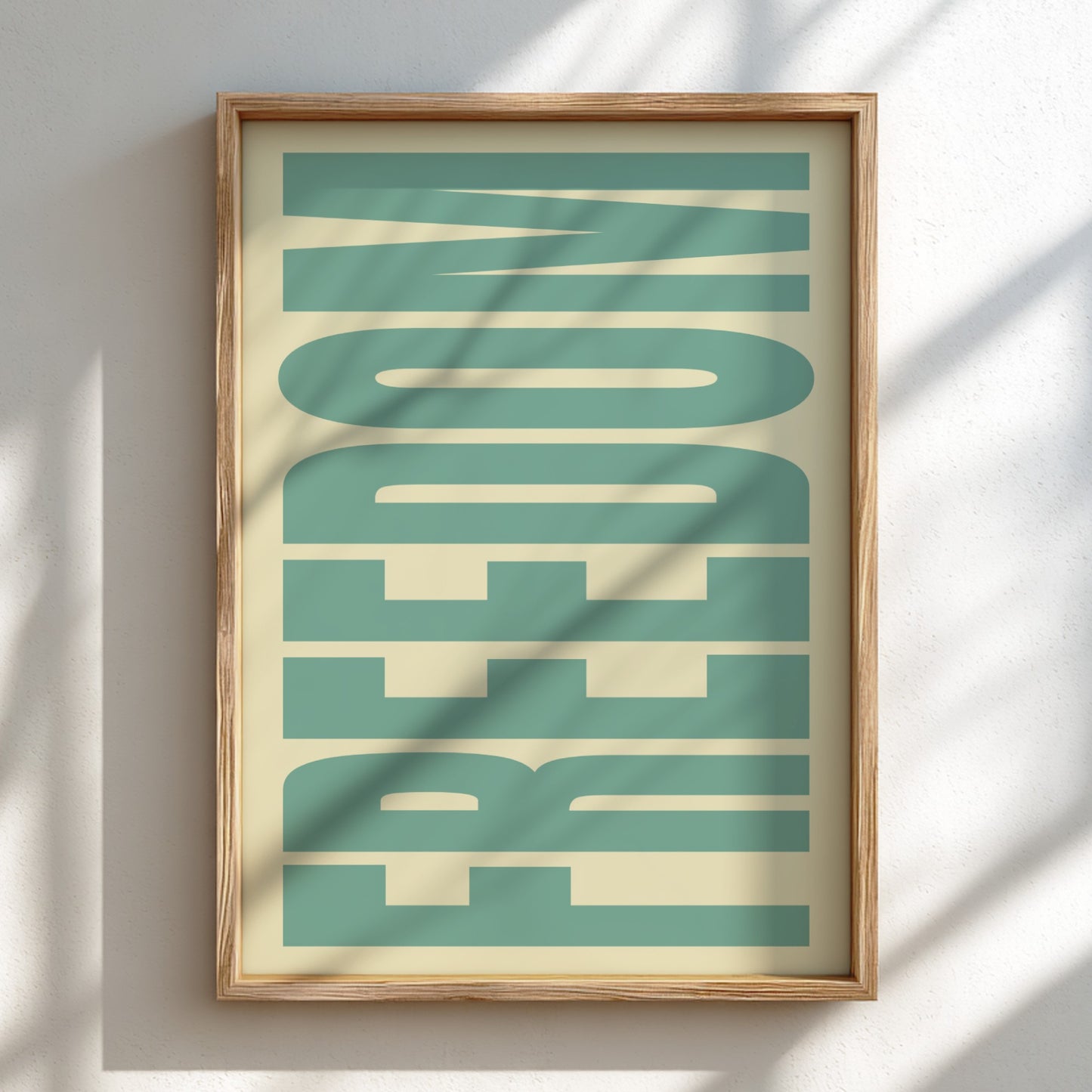Framed artwork with the word 'FREEDOM' in teal on a beige background