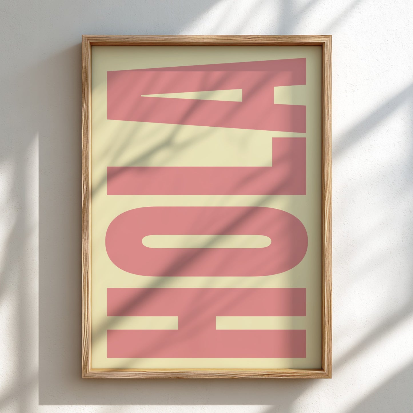 Framed artwork with 'HOLA' in pink on a light background