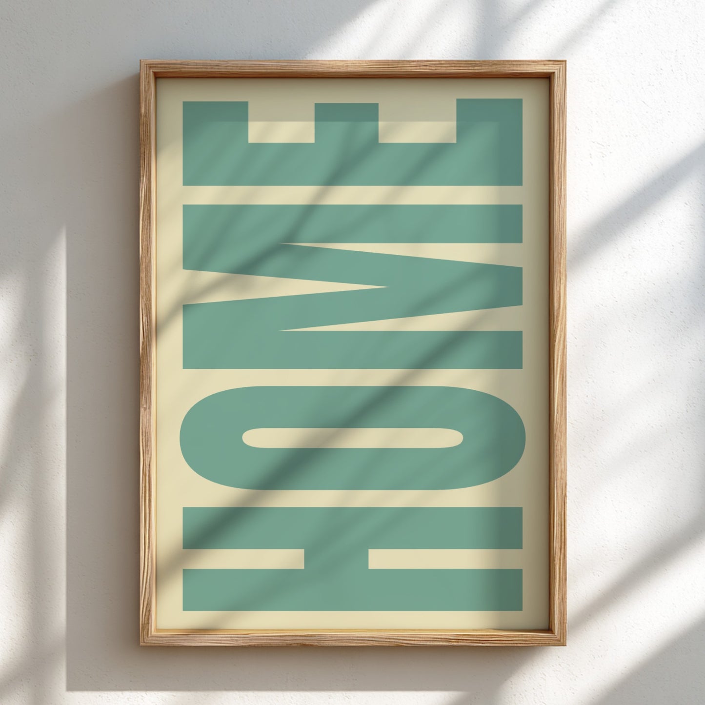 Framed artwork with the word 'HOME' in teal letters on a beige background