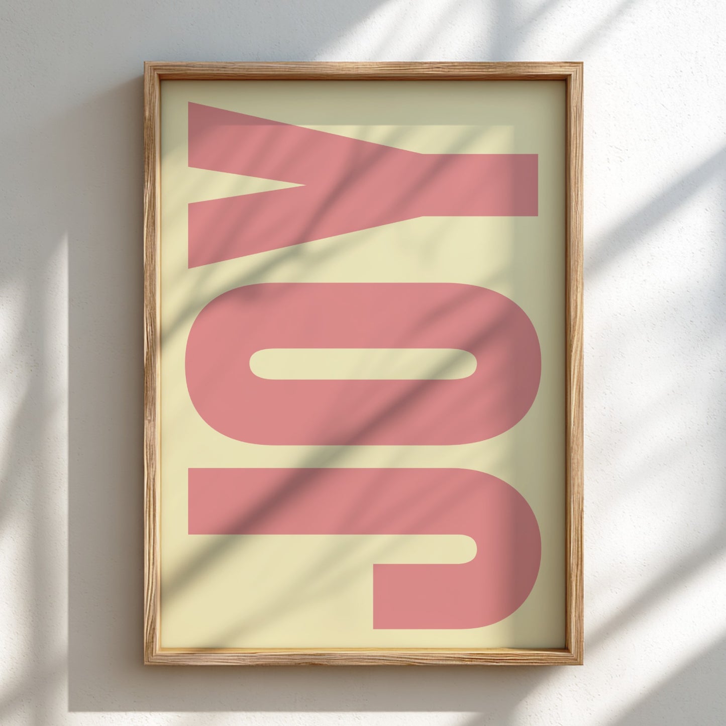 Framed artwork with the word 'JOY' in pink on a light background