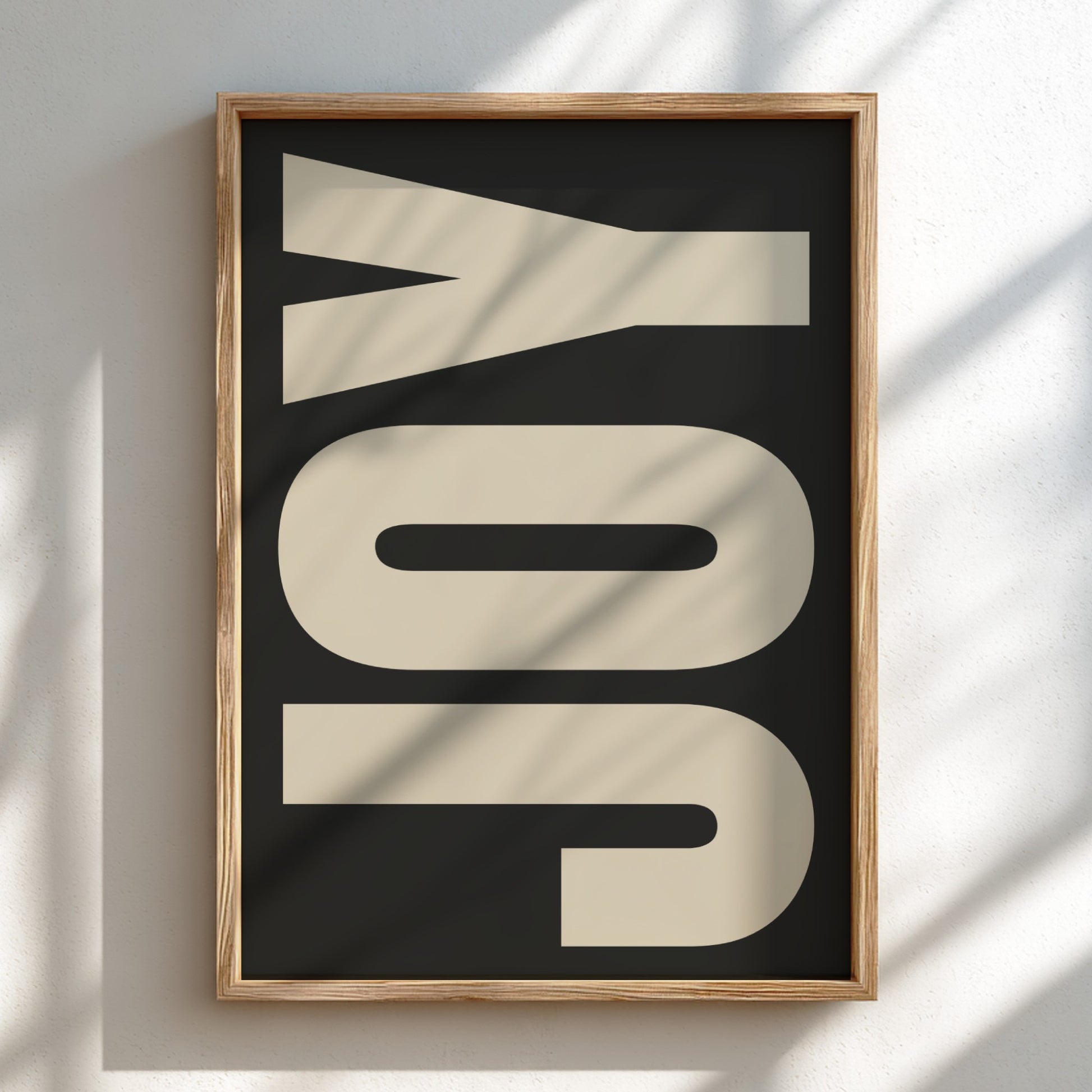 Framed artwork with the word 'JOY' on a black background