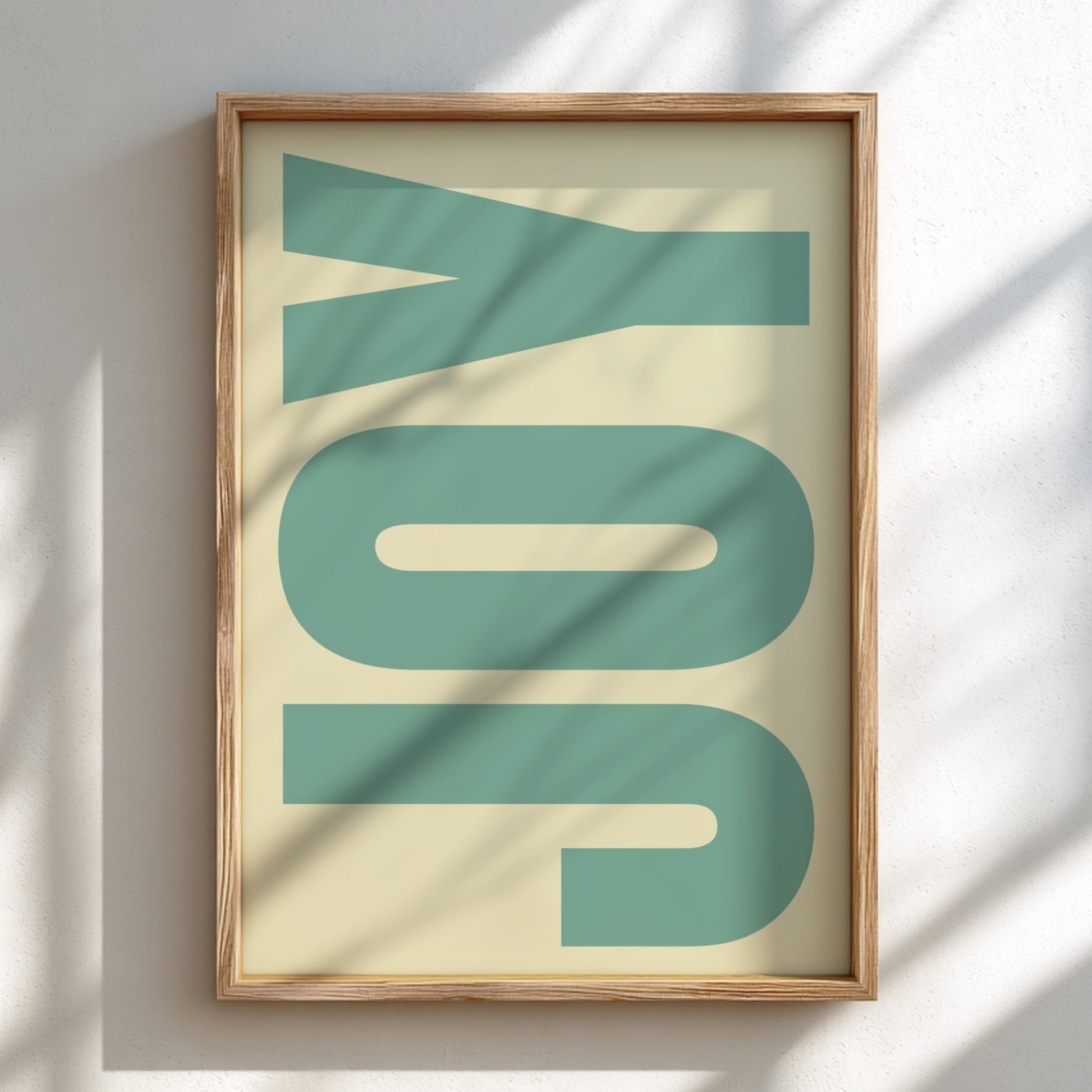 Framed artwork with the word 'JOY' in teal on a beige background