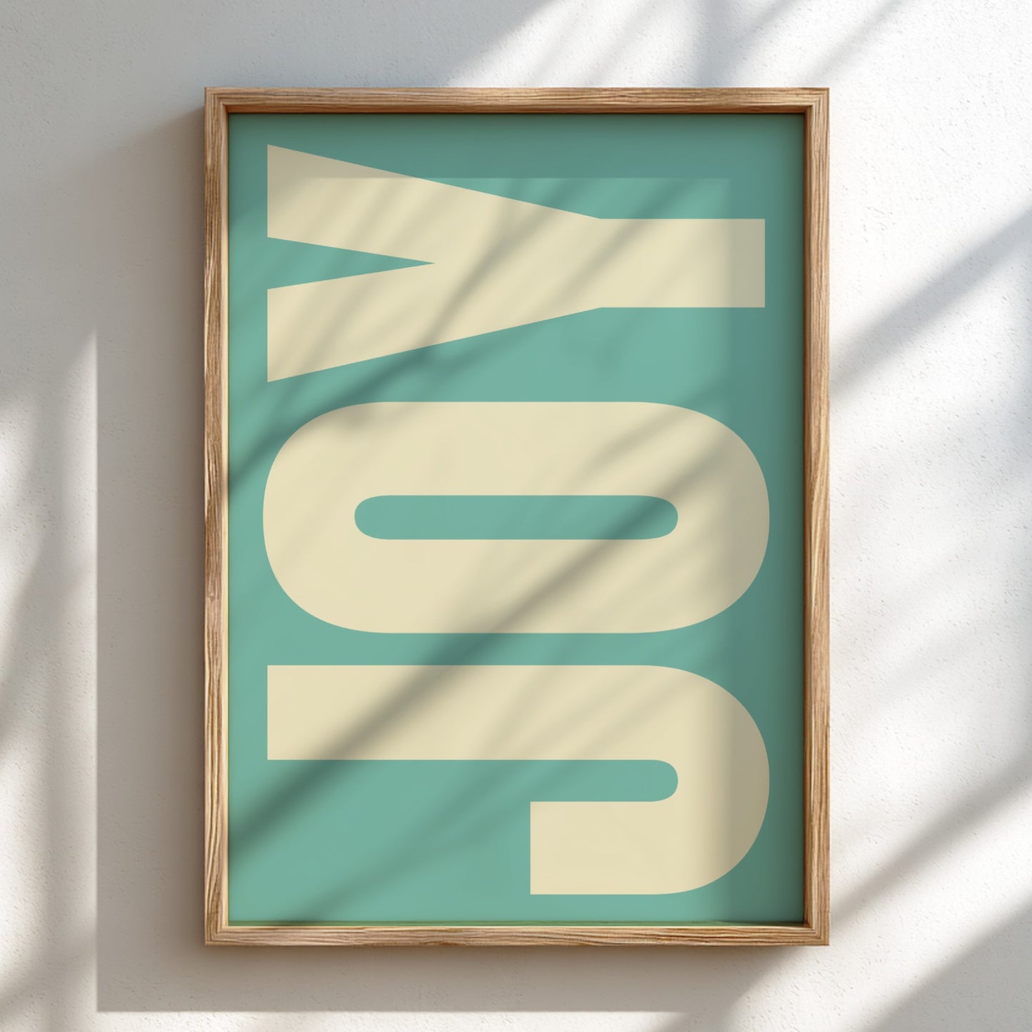 Framed artwork with 'JOY' on a teal background