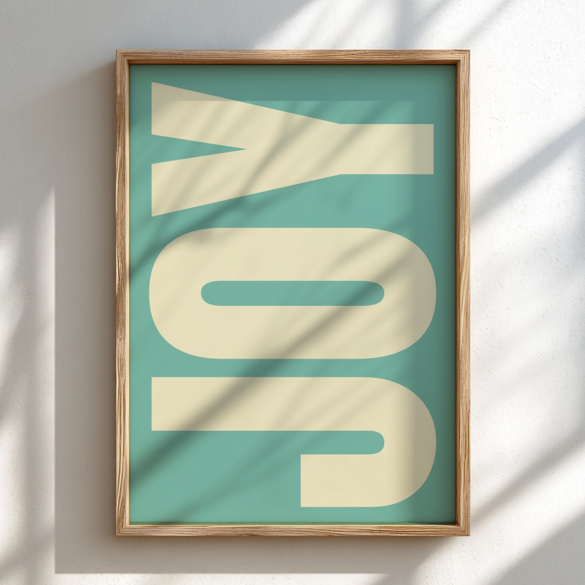 Framed artwork with 'JOY' on a teal background