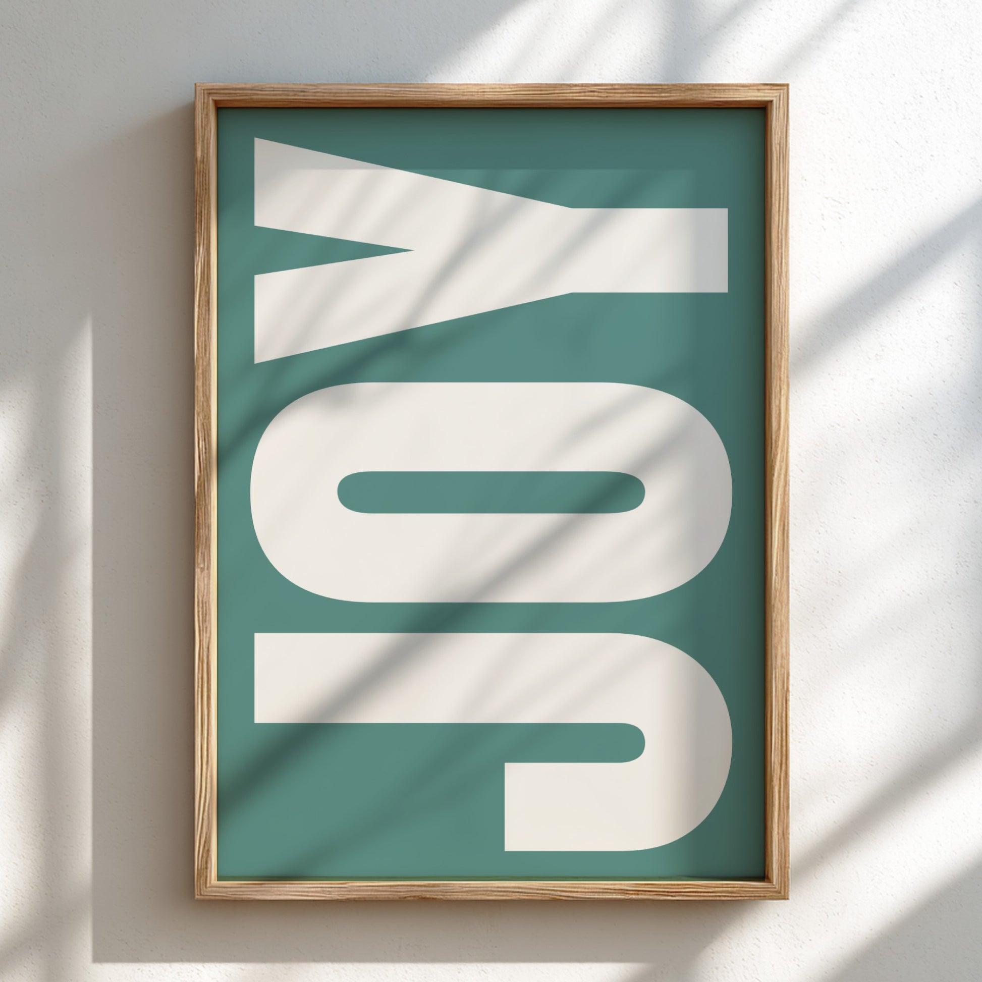 Framed artwork with 'JOY' on a teal background