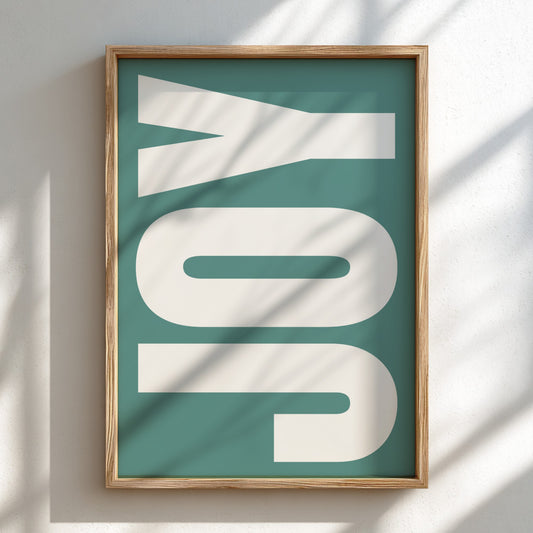 Framed artwork with 'JOY' on a teal background
