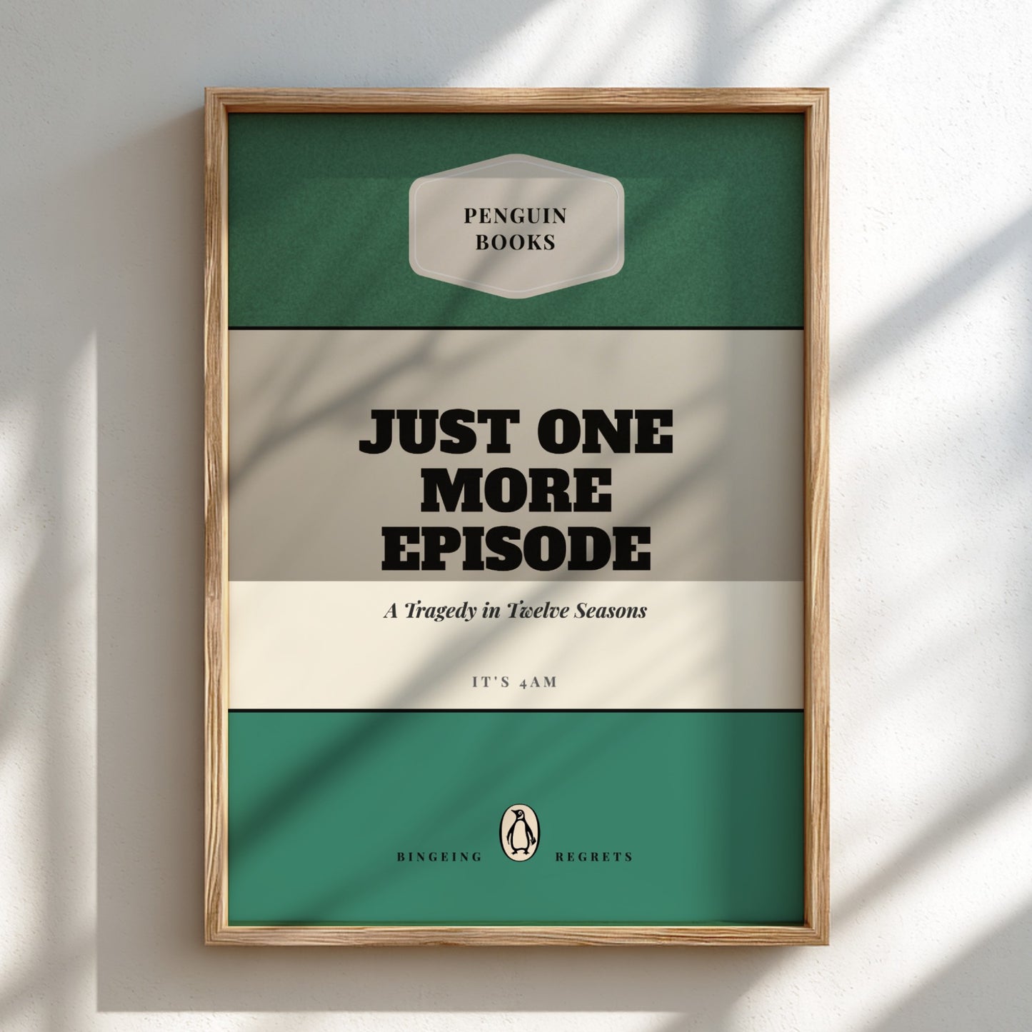 Framed poster with 'Penguin Books' design and text 'Just One More Episode' on a light background