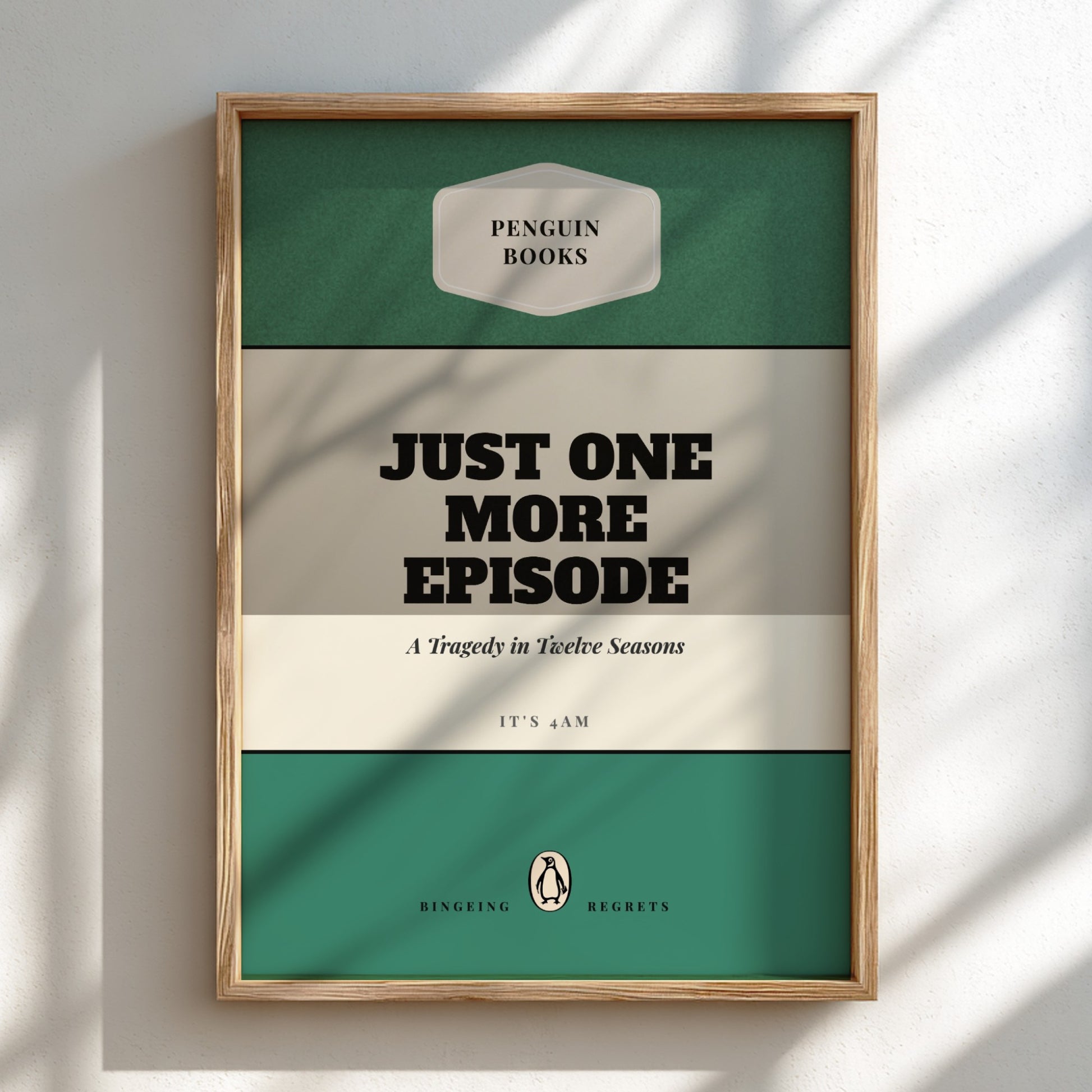 Framed poster with 'Penguin Books' design and text 'Just One More Episode' on a light background