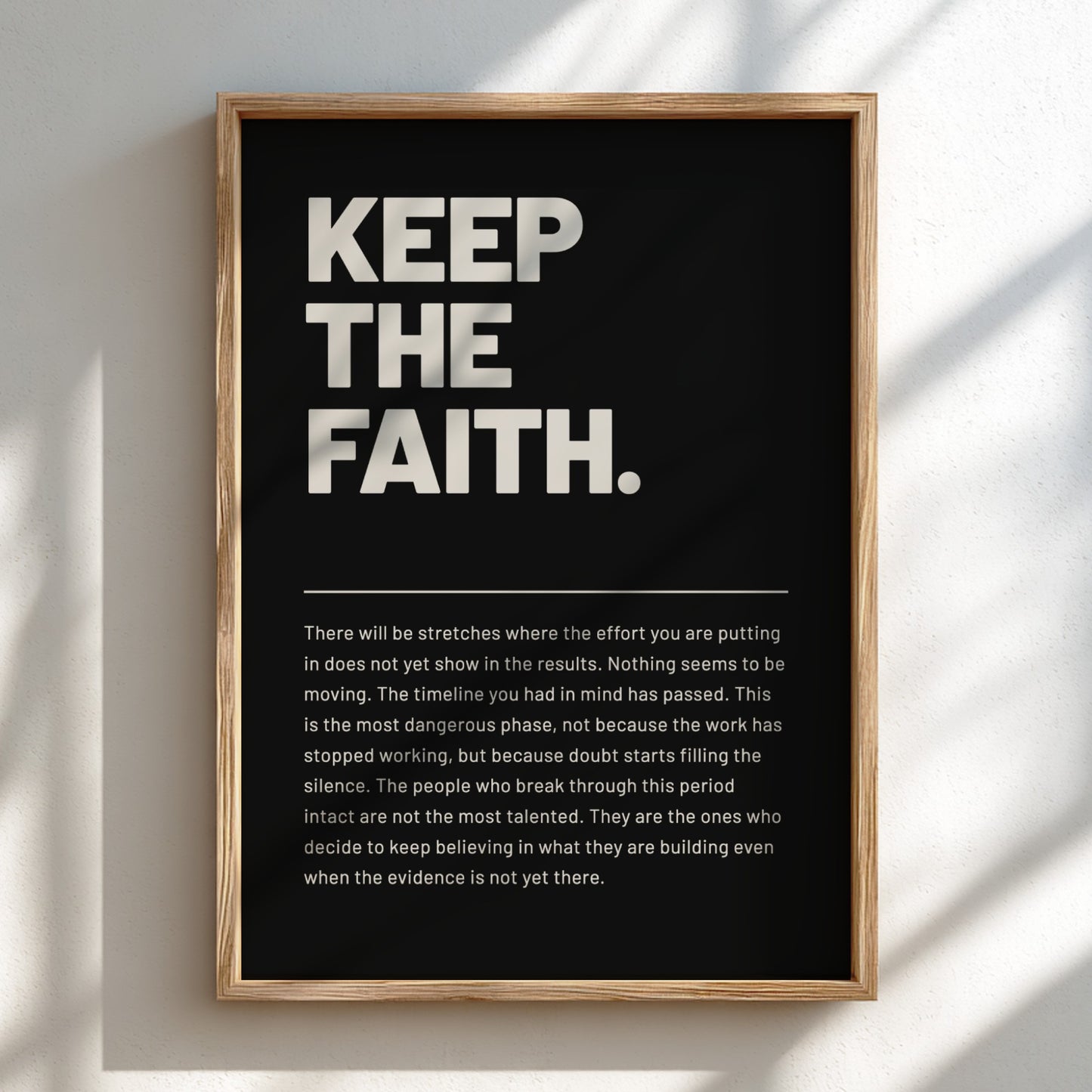Framed poster with motivational text 'KEEP THE FAITH.' on a black background