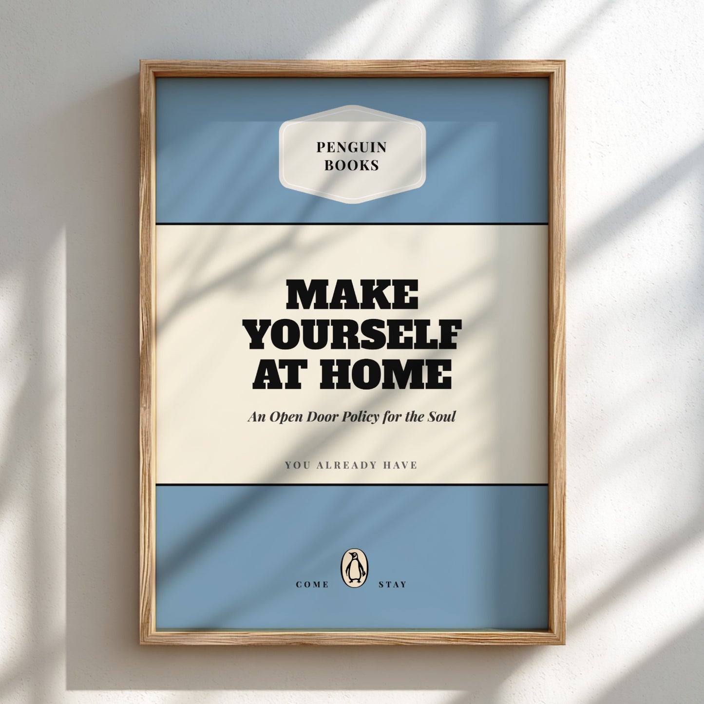 Framed Penguin Books poster with 'Make Yourself at Home' text on a light background
