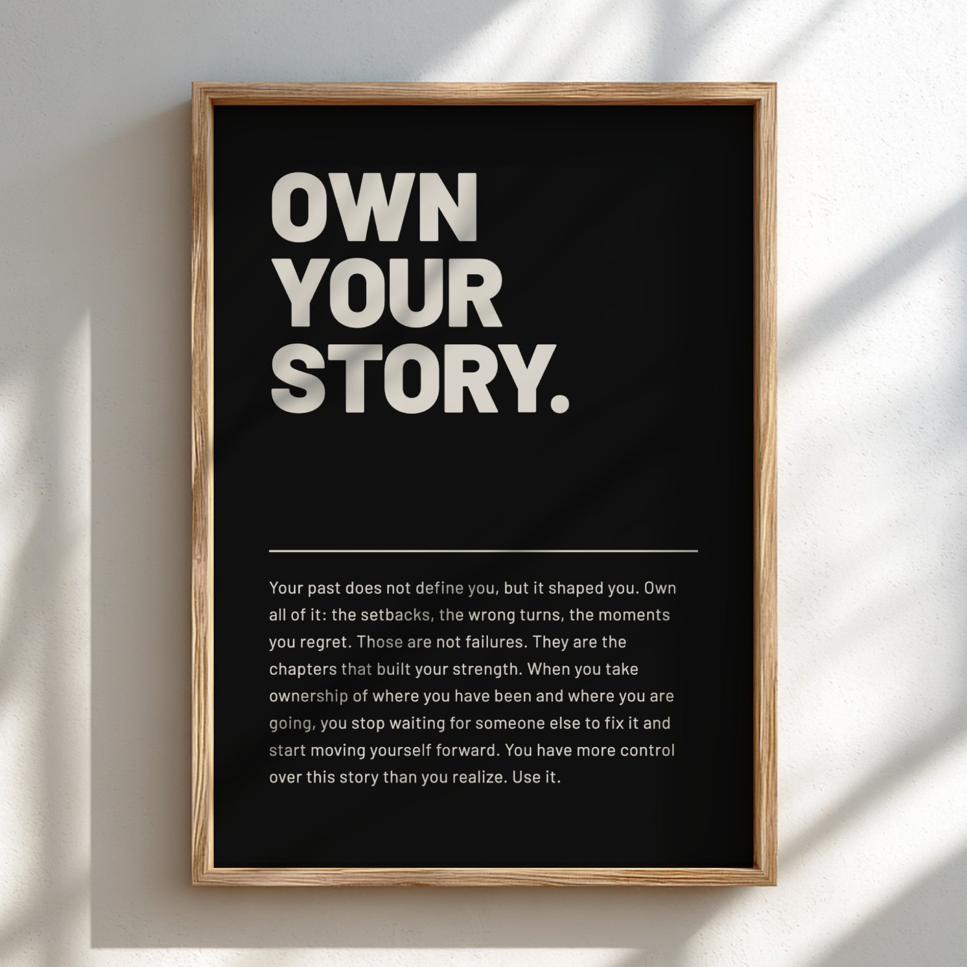 Framed poster with 'Own Your Story' text on a black background