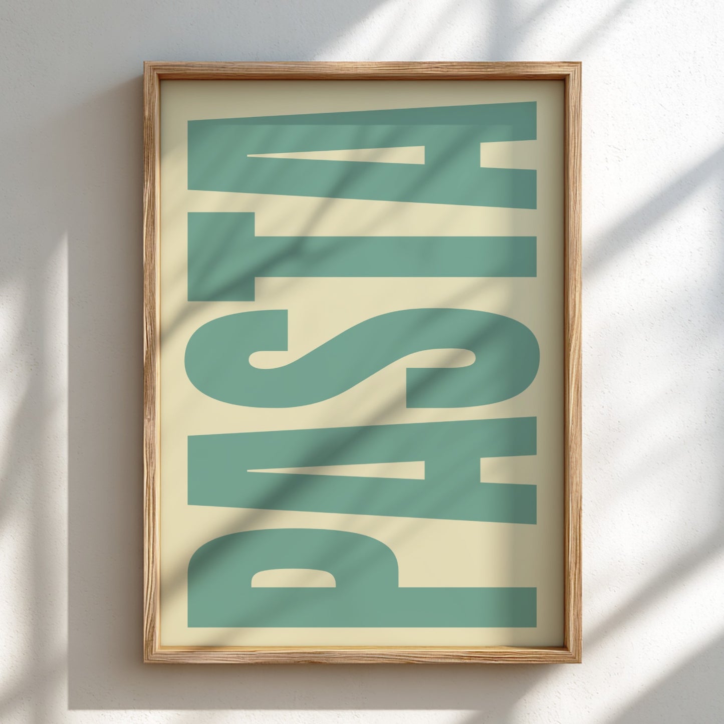 Framed artwork with the word 'PASTA' in large, green letters on a beige background.