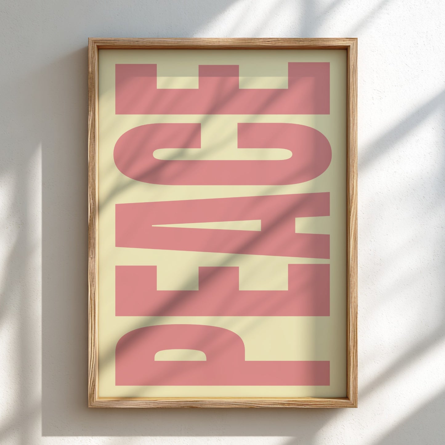 Framed artwork with 'PEACE' in pink on a light background