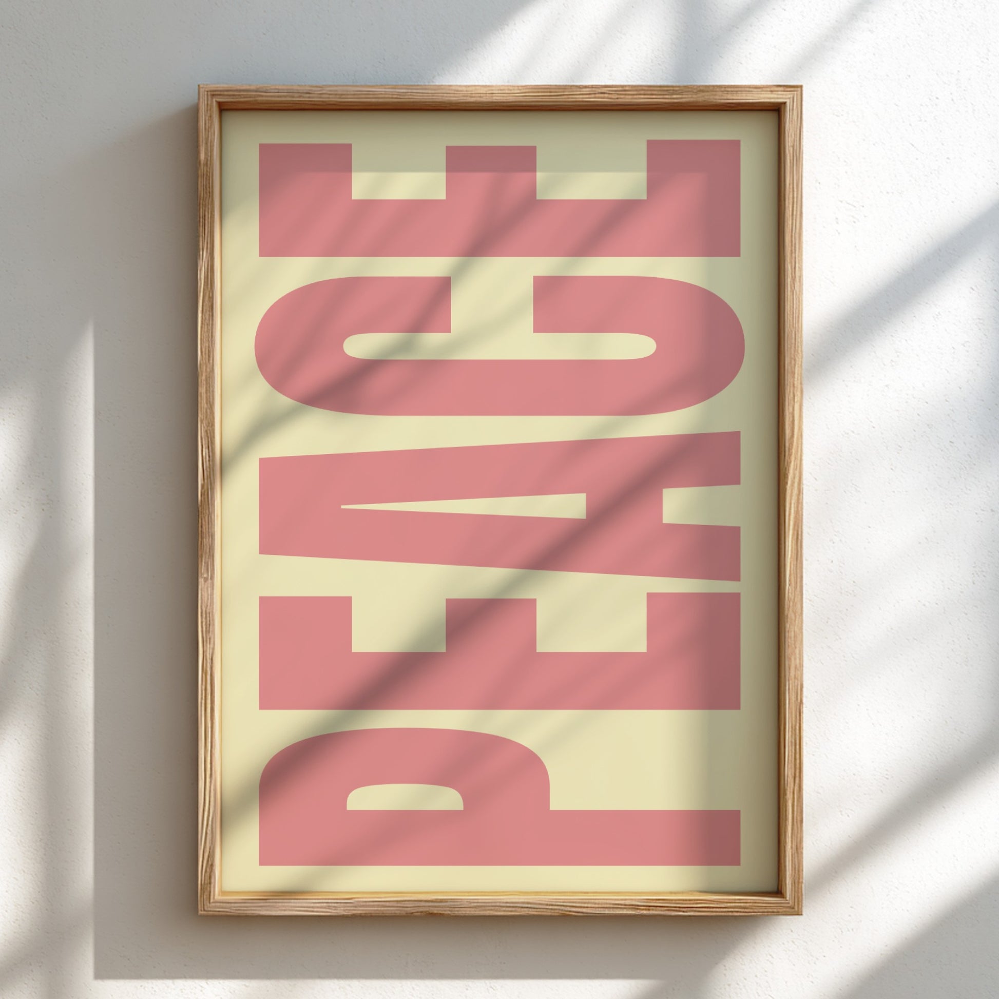 Framed artwork with 'PEACE' in pink on a light background
