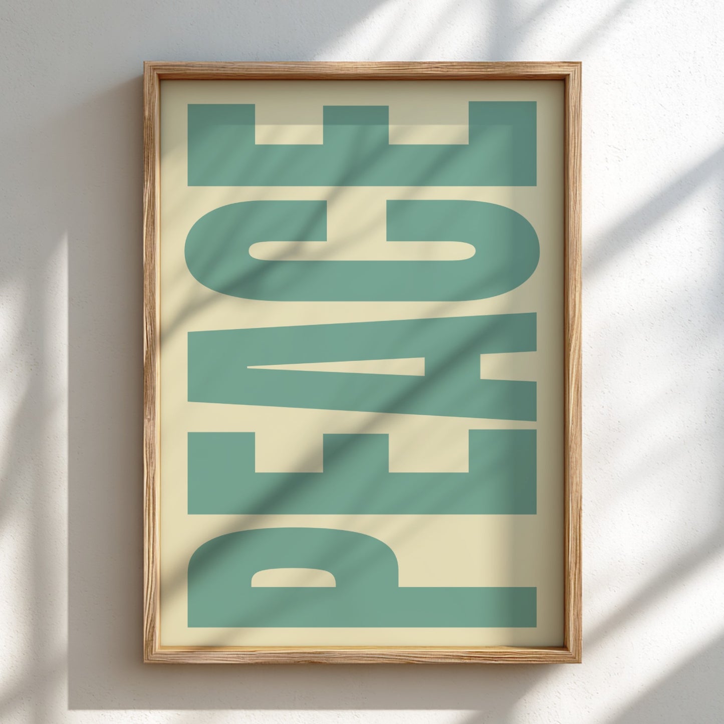 Framed artwork with the word 'PEACE' in green on a beige background
