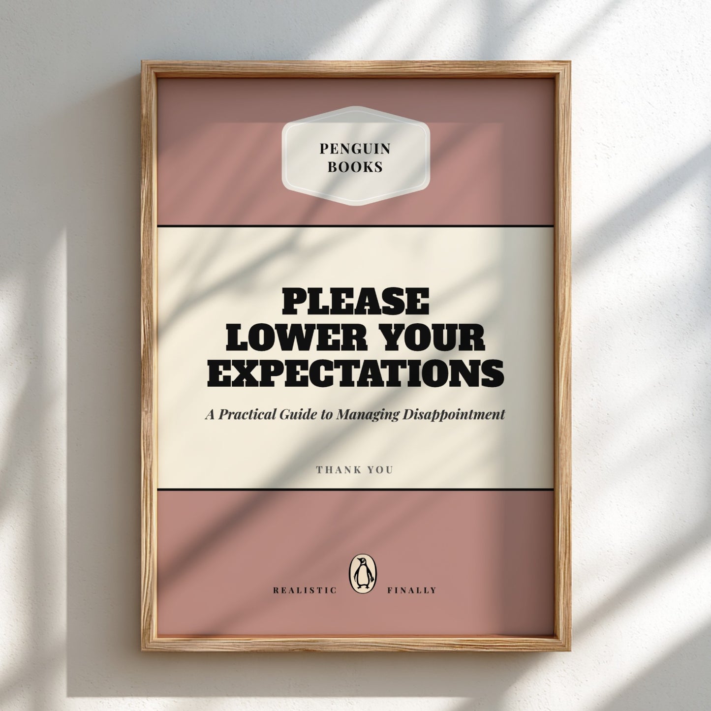 Framed book cover with 'Please Lower Your Expectations' text on a light background