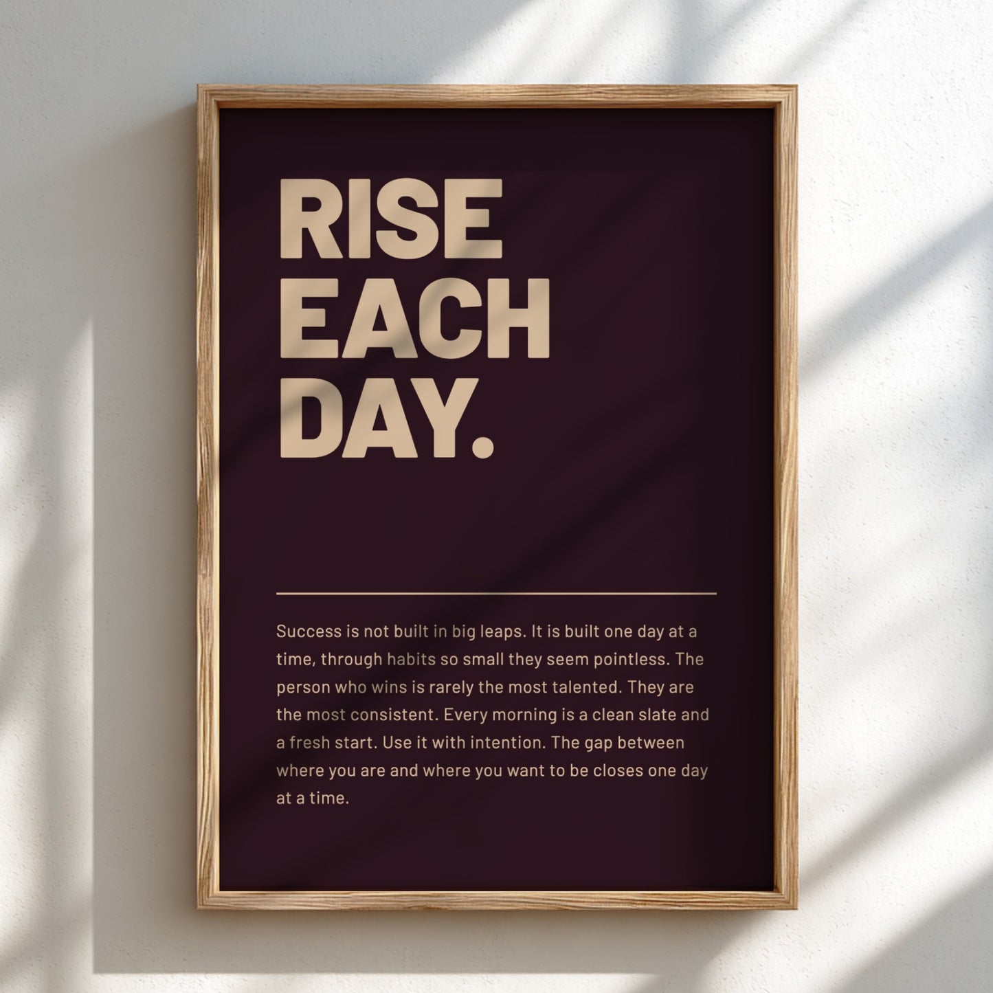 Framed motivational poster with 'RISE EACH DAY.' text on a dark background