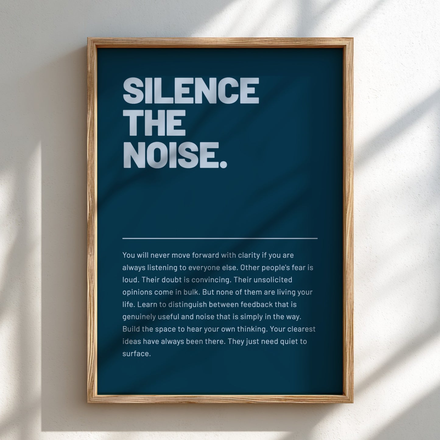 Framed poster with motivational quote 'Silence the Noise' on a blue background