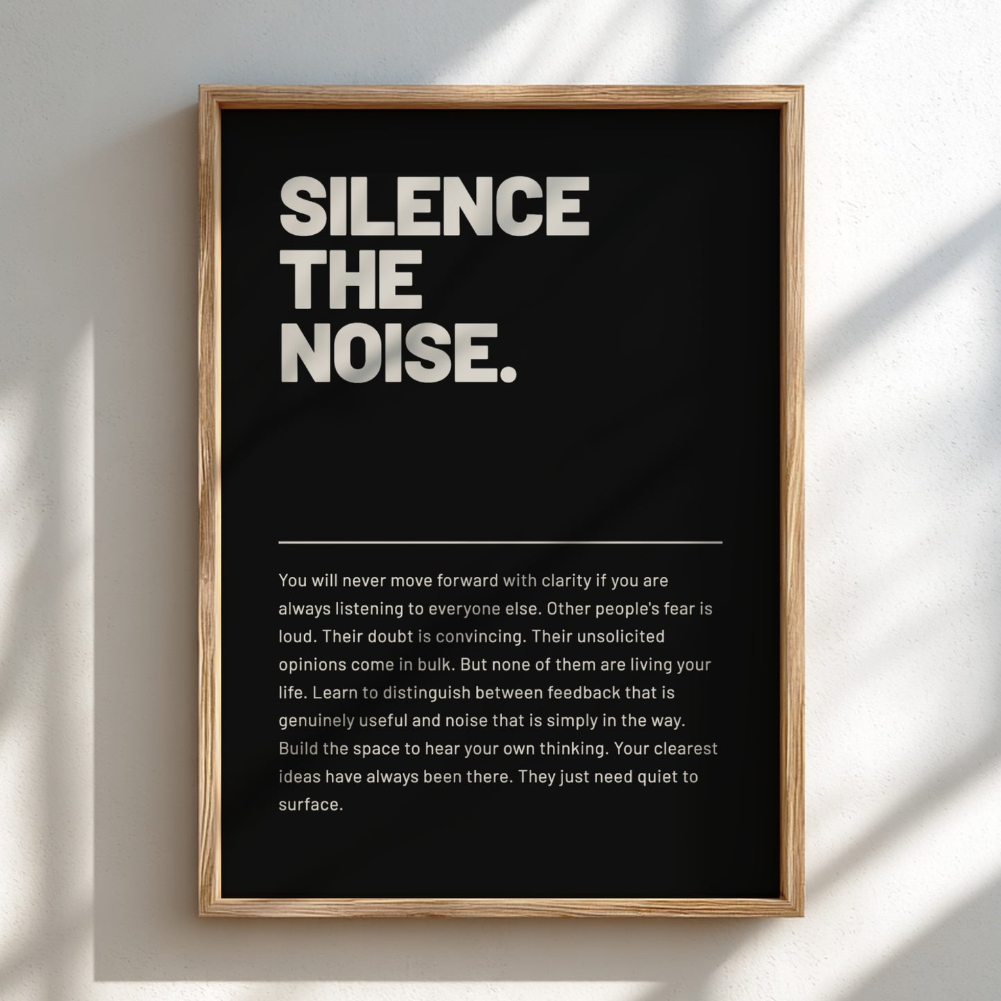 Framed poster with motivational quote 'Silence the Noise' on a black background
