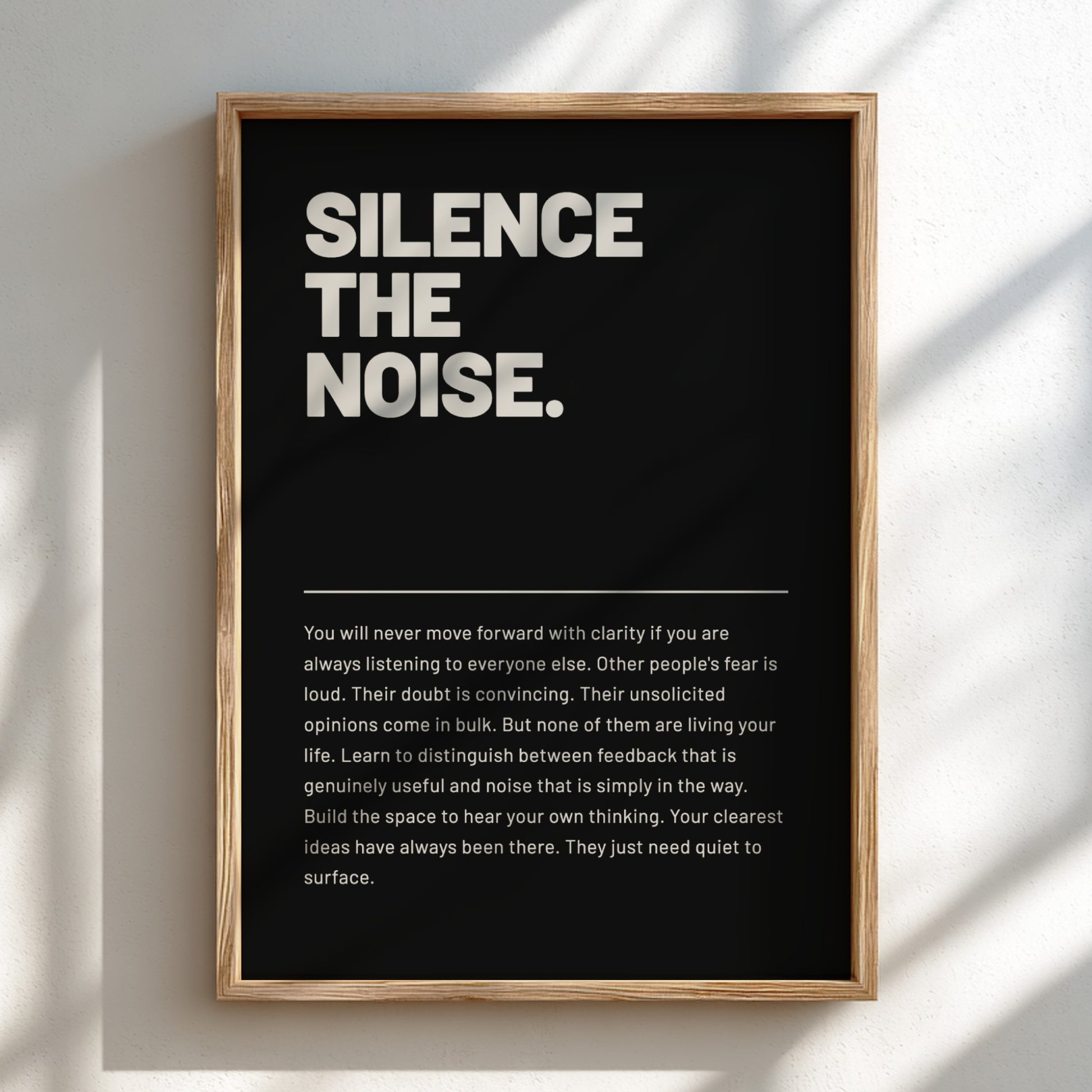 Framed poster with motivational quote 'Silence the Noise' on a black background