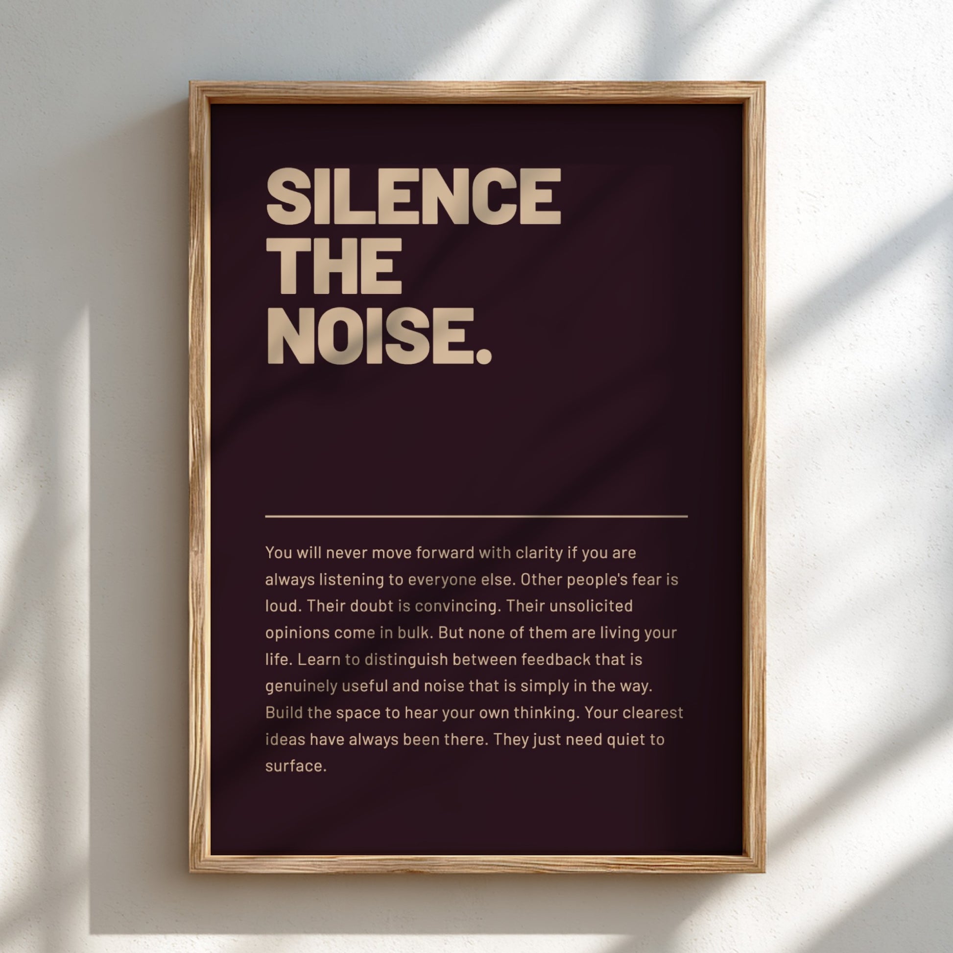 Framed poster with motivational quote 'Silence the Noise' on a dark background