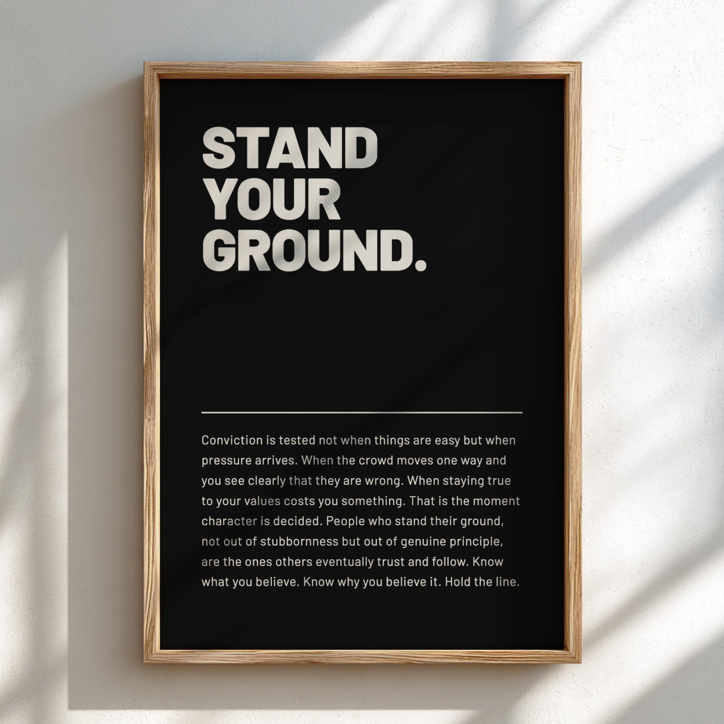 Framed poster with text 'STAND YOUR GROUND' on a black background